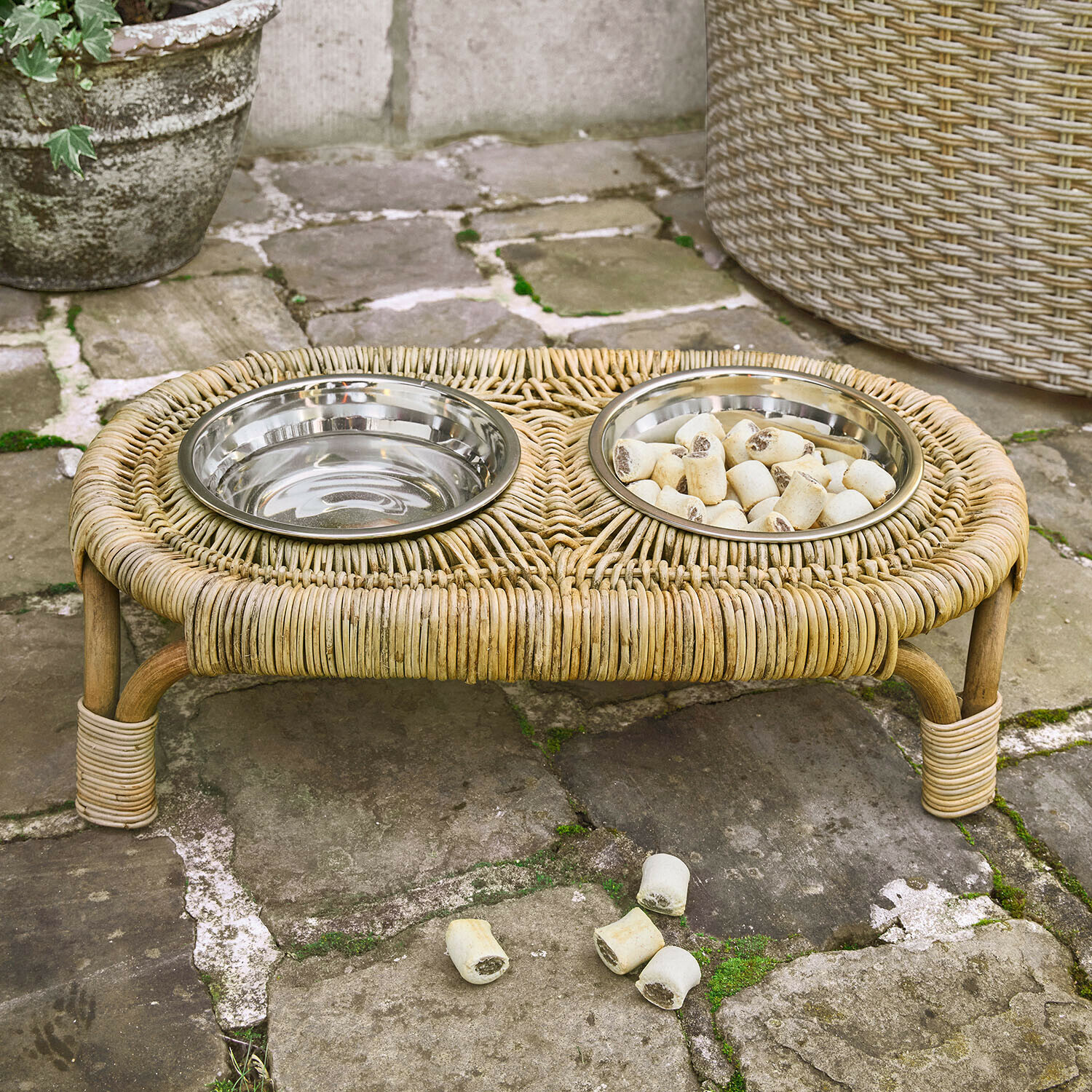 Dubbele dierenbak met metalen kommen op een natuurlijke rotan standaard