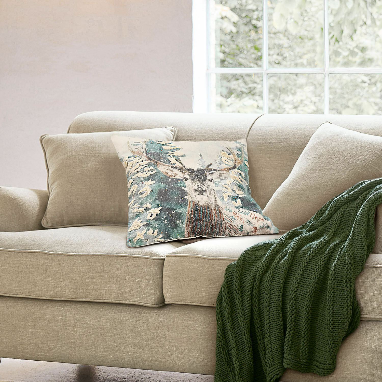 Kussenhoes Elvaris Beige bank met sierkussen met hertmotief en groene gebreide deken in lichte woonkamer