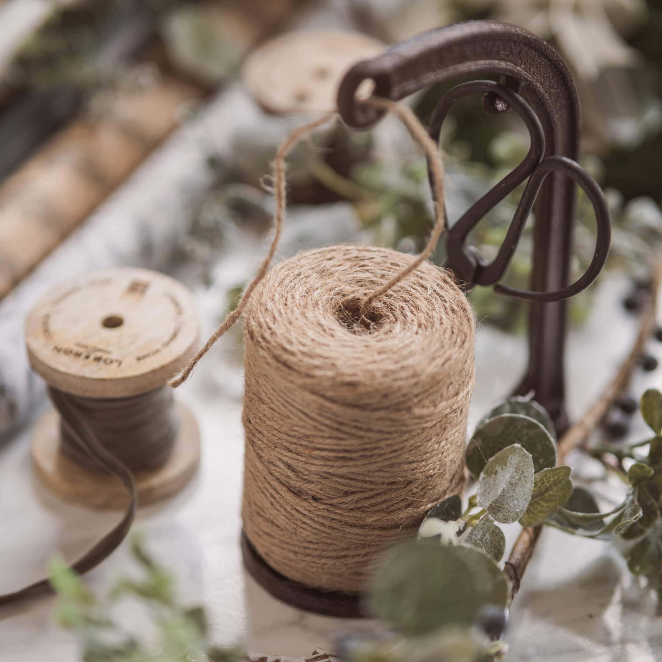 Natuurlijke juten touw op metalen houder met schaar voor decoratie en knutselen