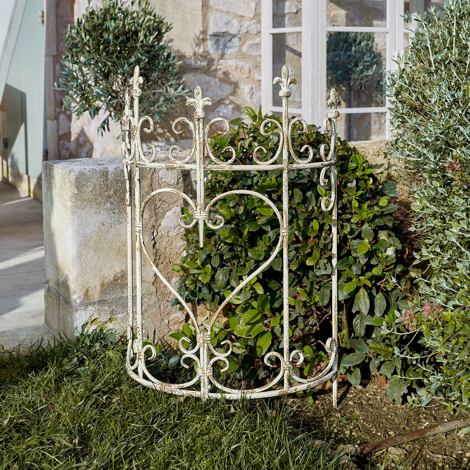 Klimplantenrek Bramwell Witte metalen tuinomheining met hartmotief en bloemrijke versieringen op groen gras