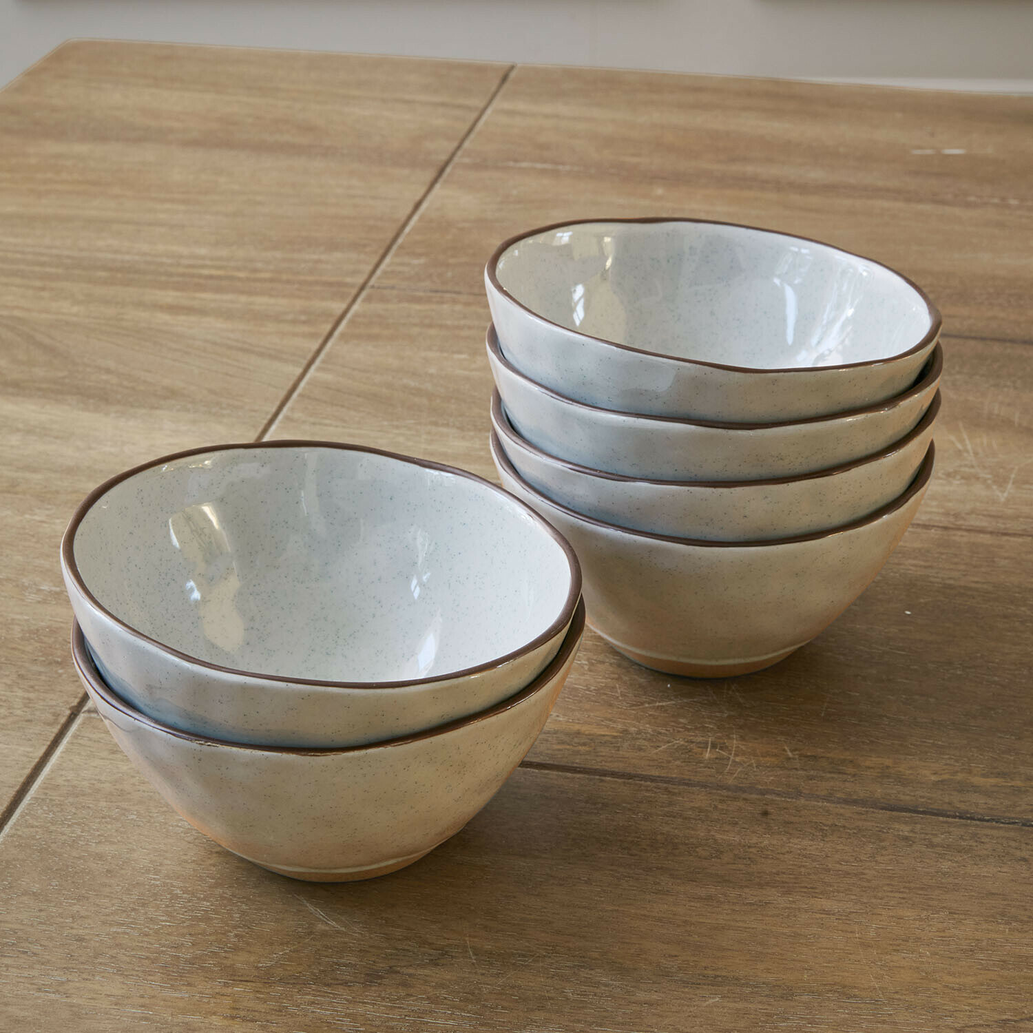 Kom set van 6 Biarré Set van zes crèmekleurige keramische kommen met bruine rand op houten tafel