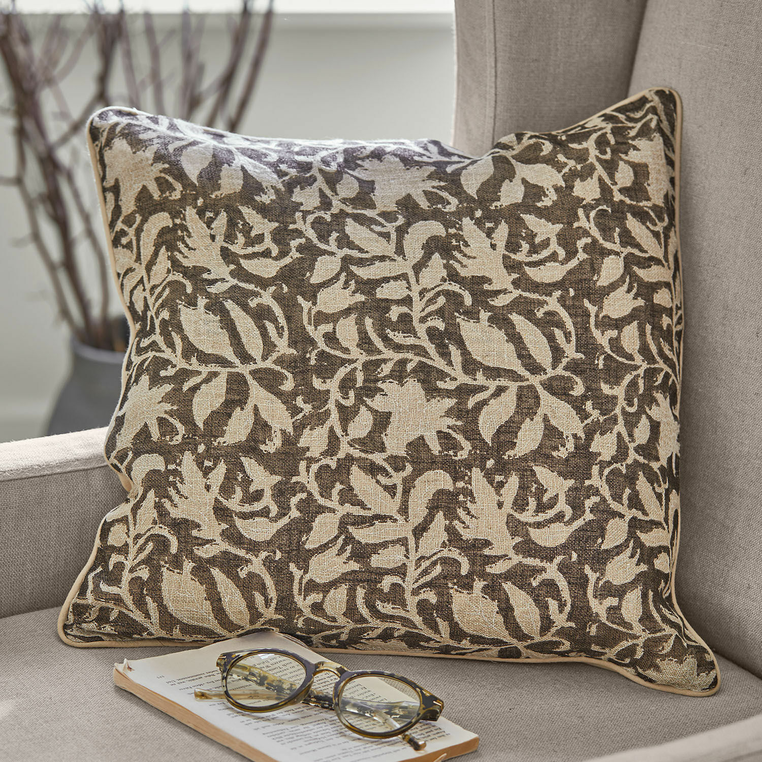 Kussenhoes set van 2 Ziradayn Bruin-beige katoenen sierkussen met plantenpatroon op grijze bank met bril en boek