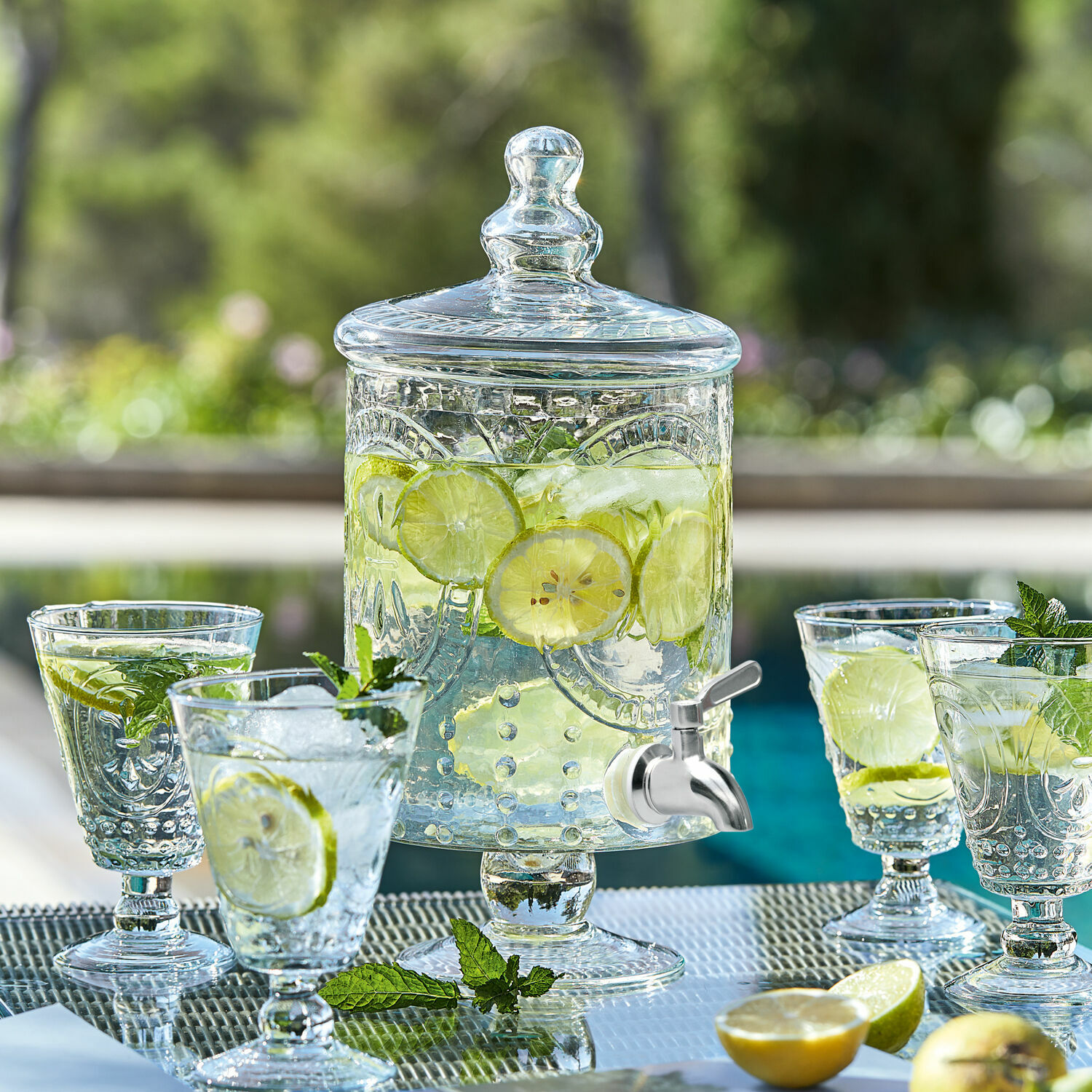Glazen drankdispenser met deksel en kraan, gevuld met citroen en munt, perfect voor zomerse feesten
