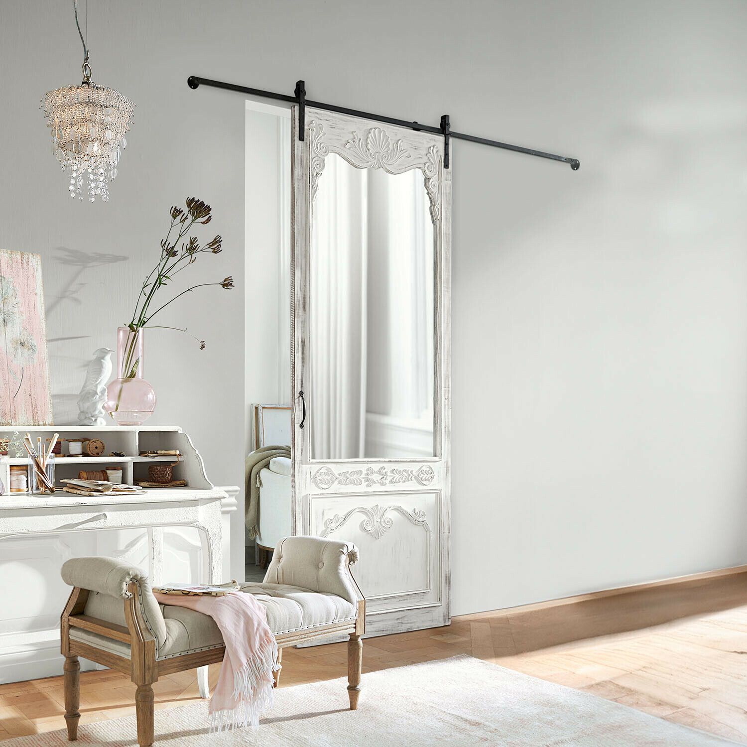 Witte houten schuifdeur met spiegel en gesneden versieringen in lichte kamer