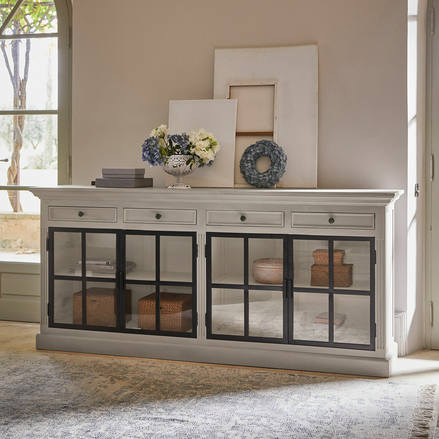Dressoir Pratola Witte houten dressoir met zwarte glazen deuren en decoraties erop in woonkamer