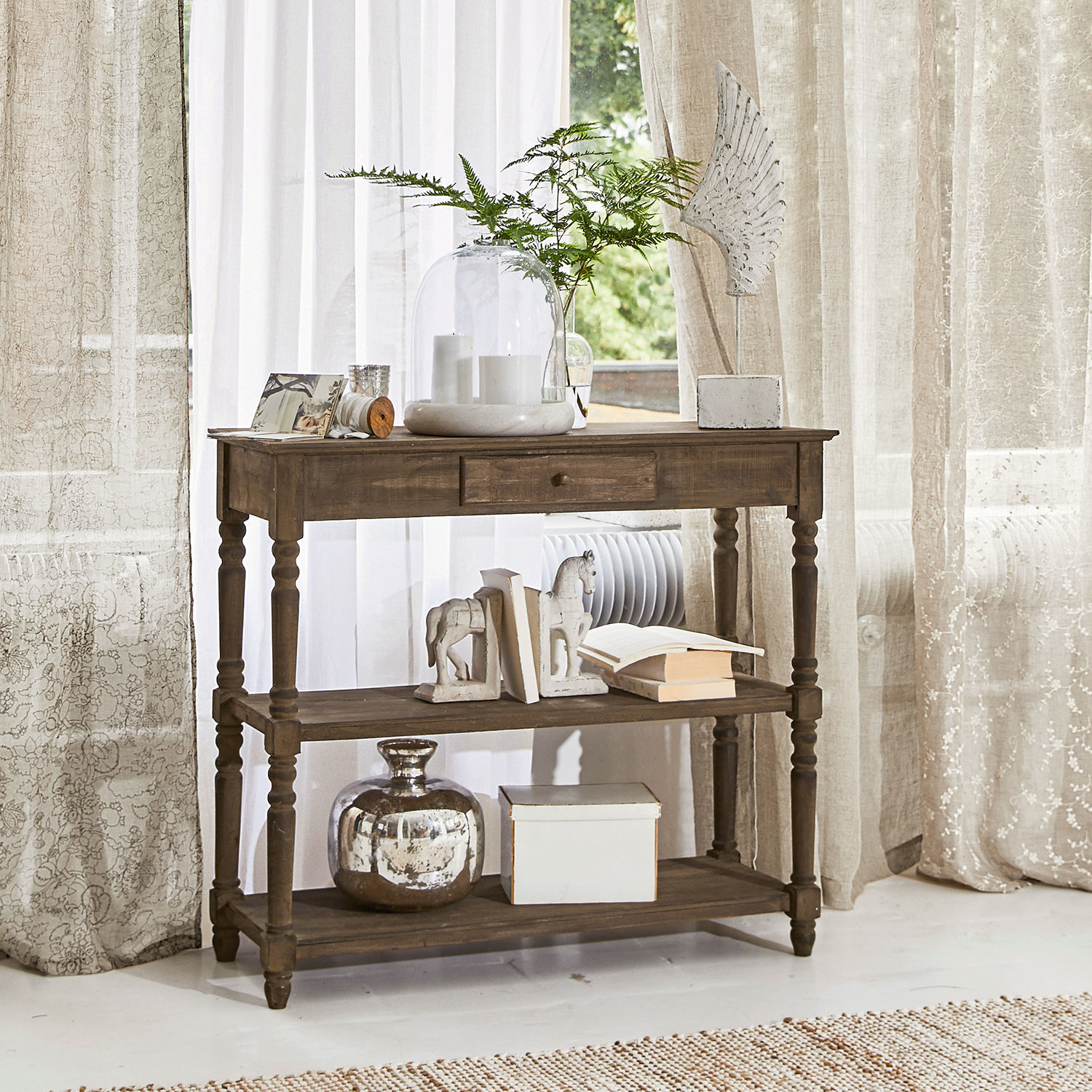 Sidetable Roubaix Bruine houten tafel met lade en planken, versierd met boeken en vazen in lichte kamer
