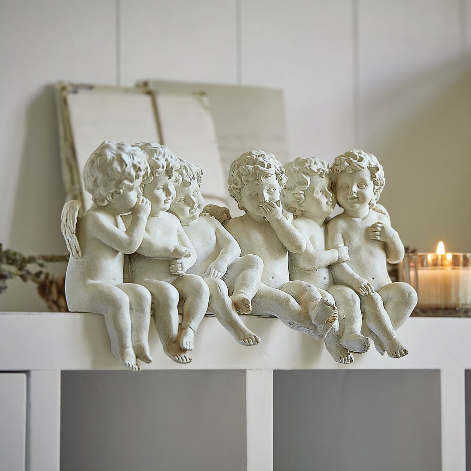 Witte engelenfiguren van kunststeen zittend op plank, decoratie voor binnenhuis