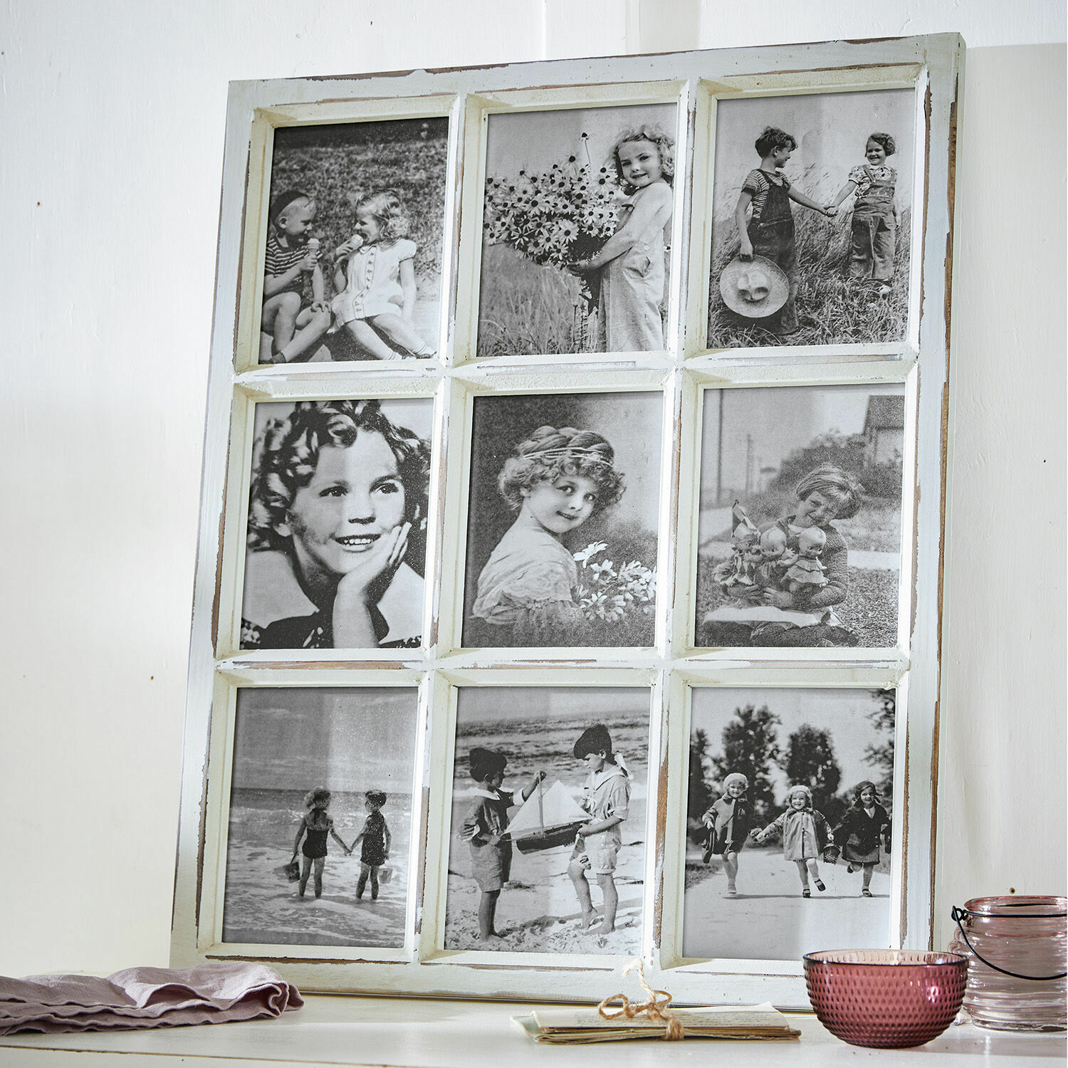 Witte houten lijst met negen zwart-wit vintage foto's van kinderen op een tafel
