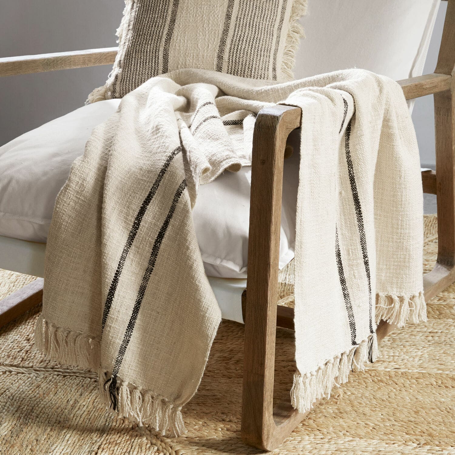 Plaid Toos Beige katoenen plaid met zwarte strepen en franjes op houten stoel in woonkamer