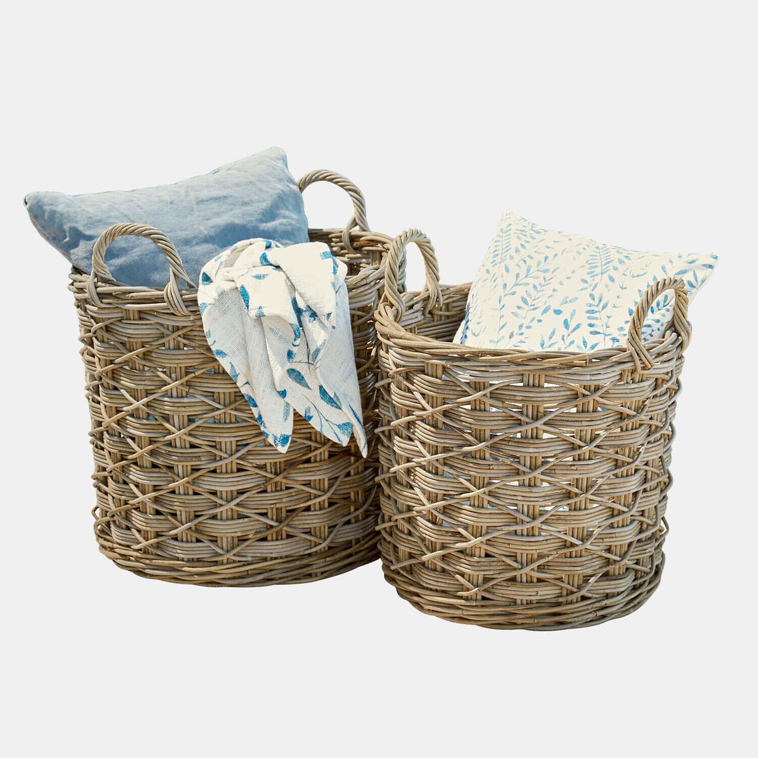 Twee natuurlijke rieten manden met kussens en blauw patroon deken voor decoratieve opslag