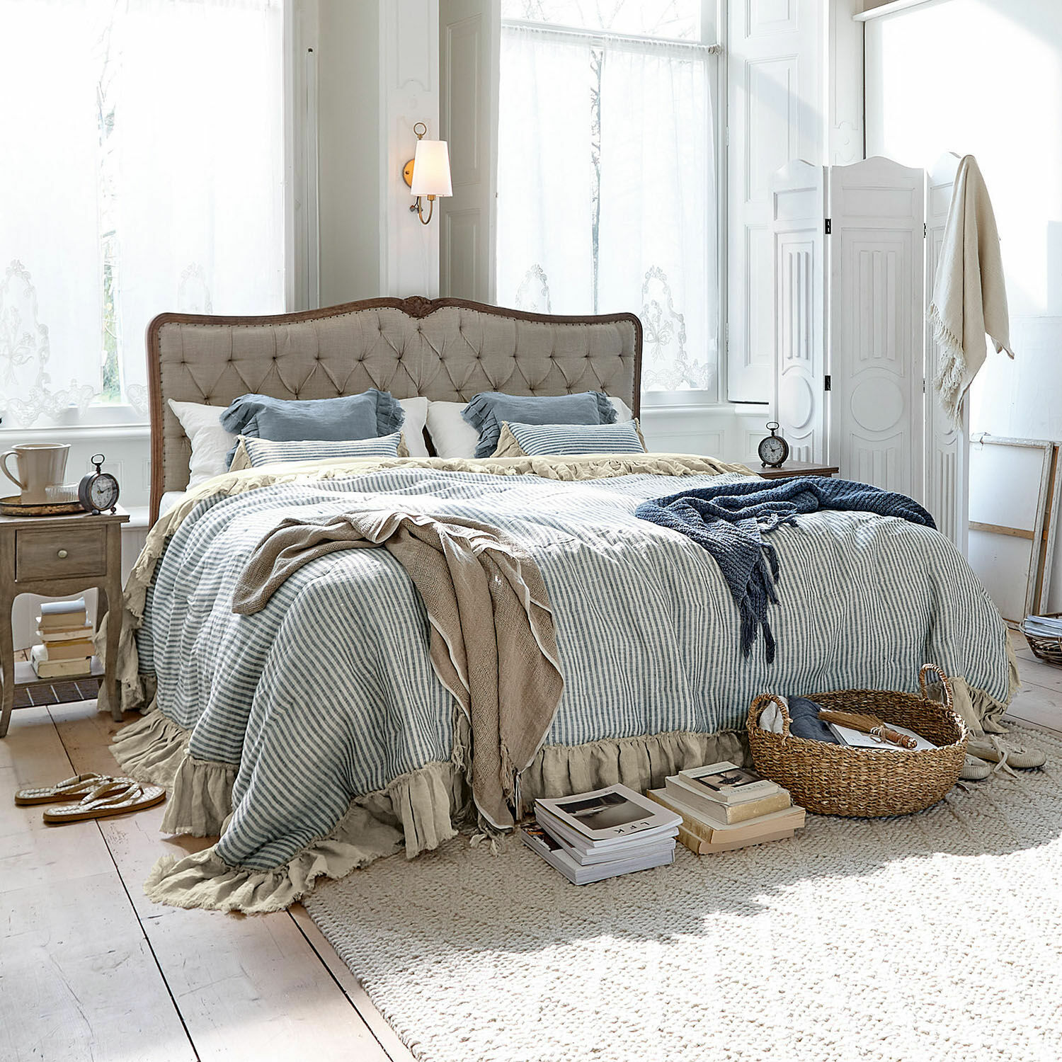 Quilt Alexane Gezellige slaapkamer met beige stoffen bed en blauw-wit gestreept beddengoed