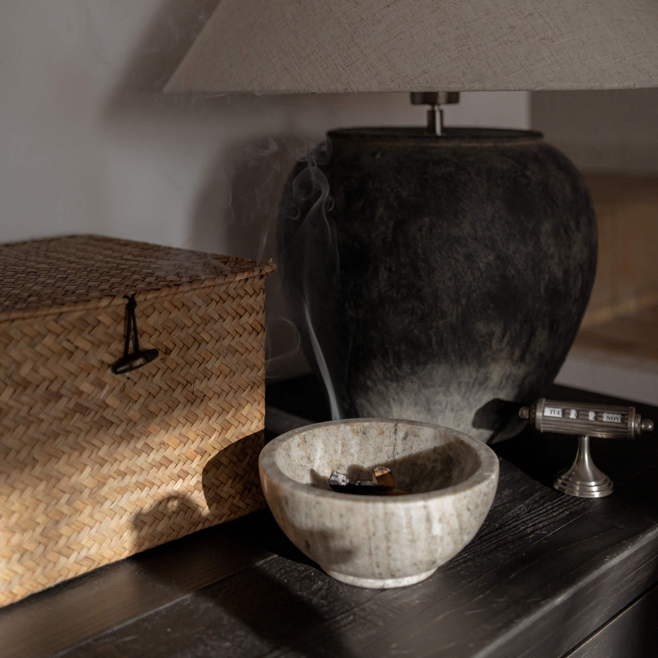 Kom van natuurlijk beige albast met rook, tafeldecoratie met lamp en rieten doos