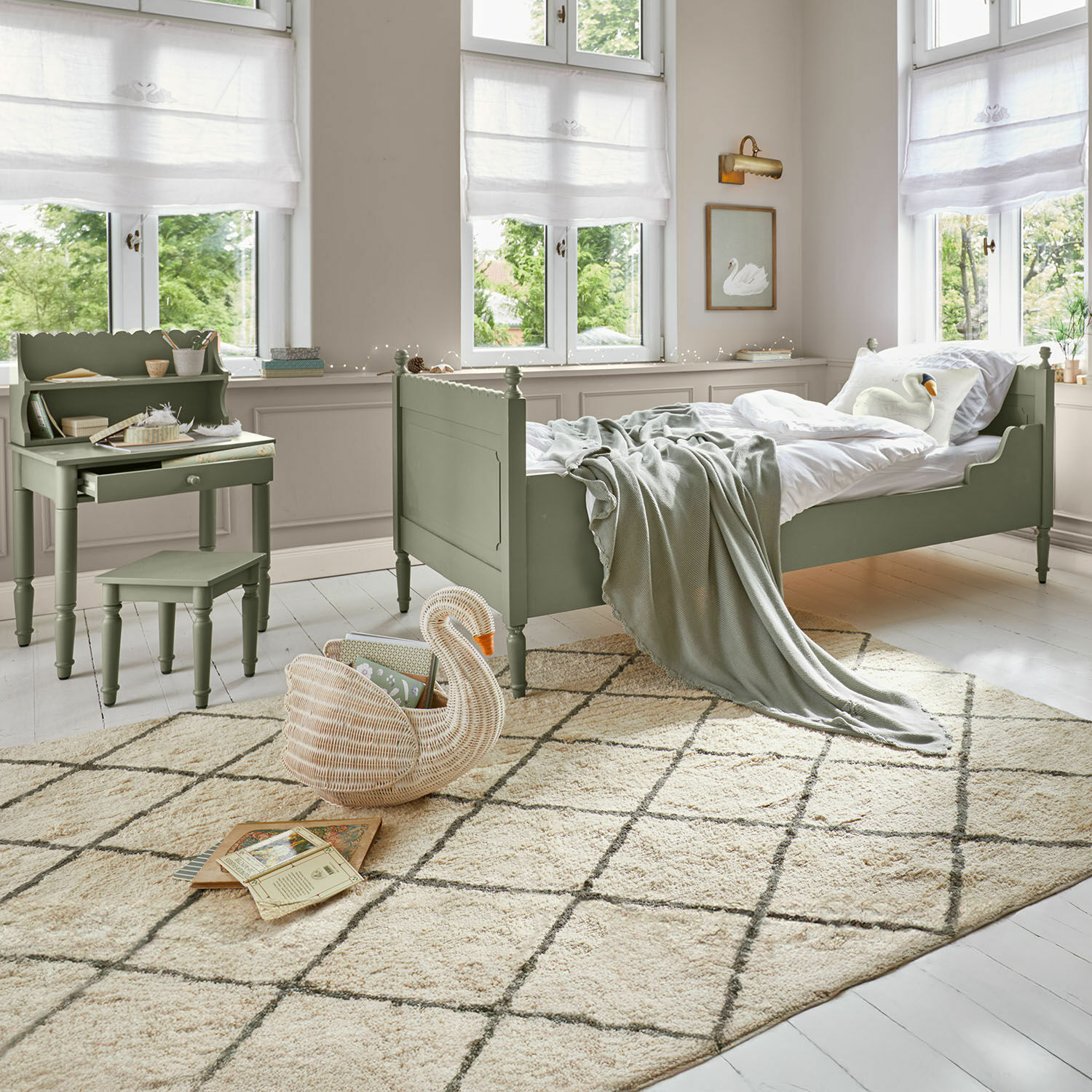 Kinderkamer met groen houten bed en bureau, zachte geruite vloerkleed op lichte vloer