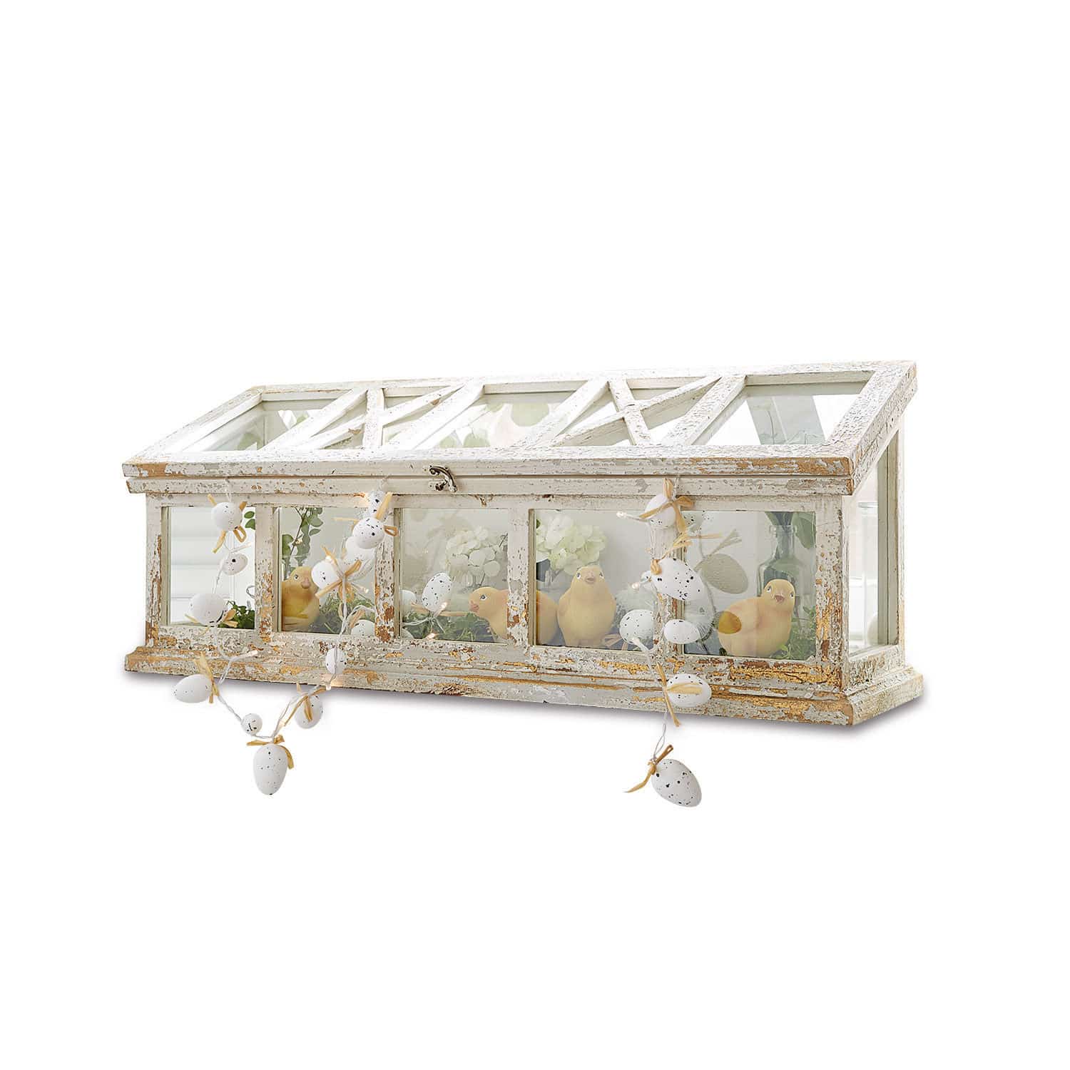 Decoratieve houten kas met witte verweerde afwerking en paasdecoraties met gele vogeltjes binnenin