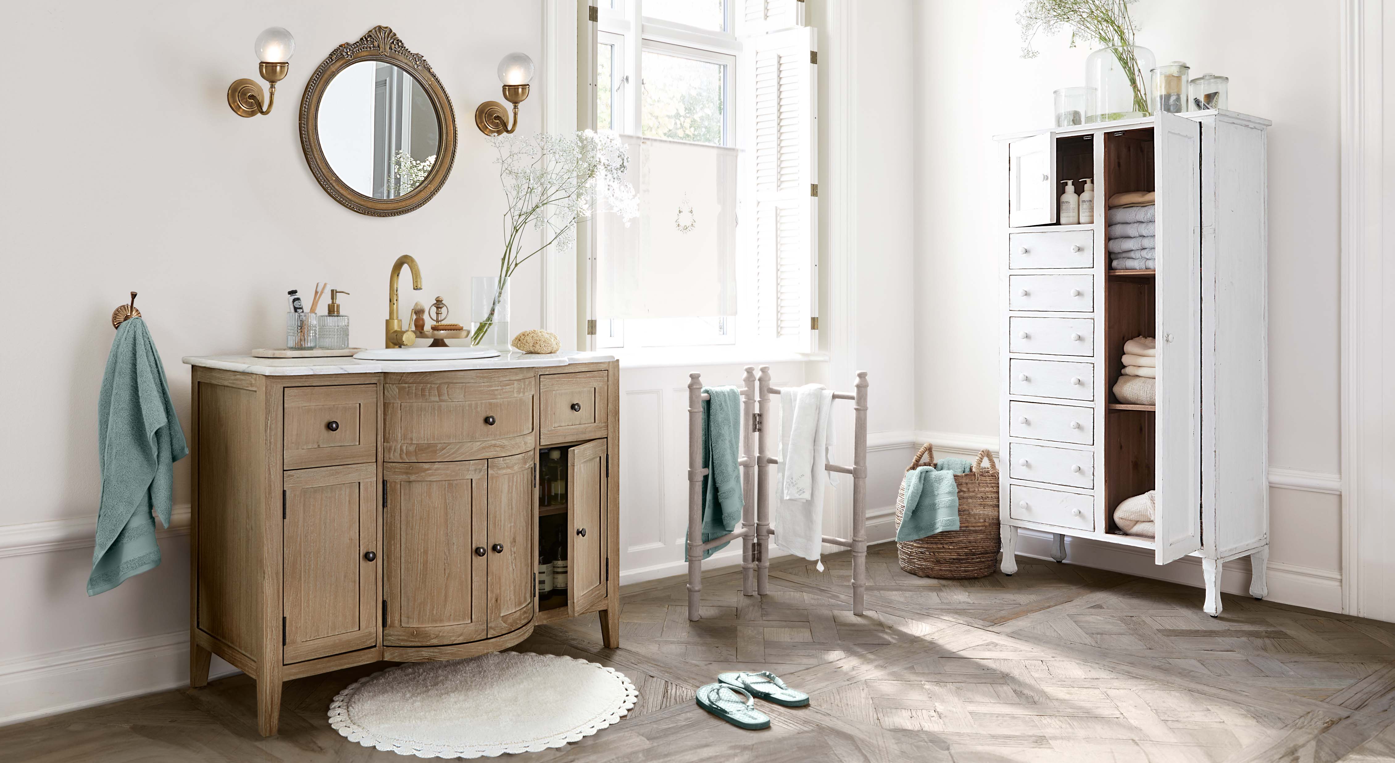 Badkamer met houten wastafelmeubel, witte kast en turquoise handdoeken, lichte natuurlijke houttinten