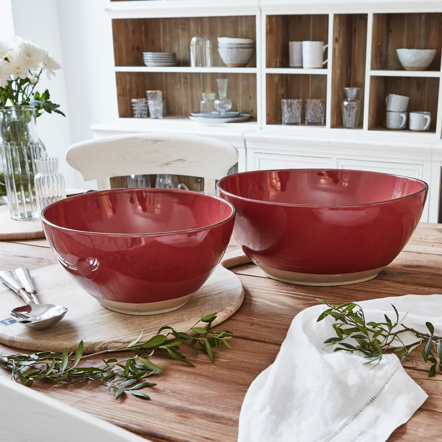 Set van twee rode keramische kommen op een houten tafel in een lichte keuken