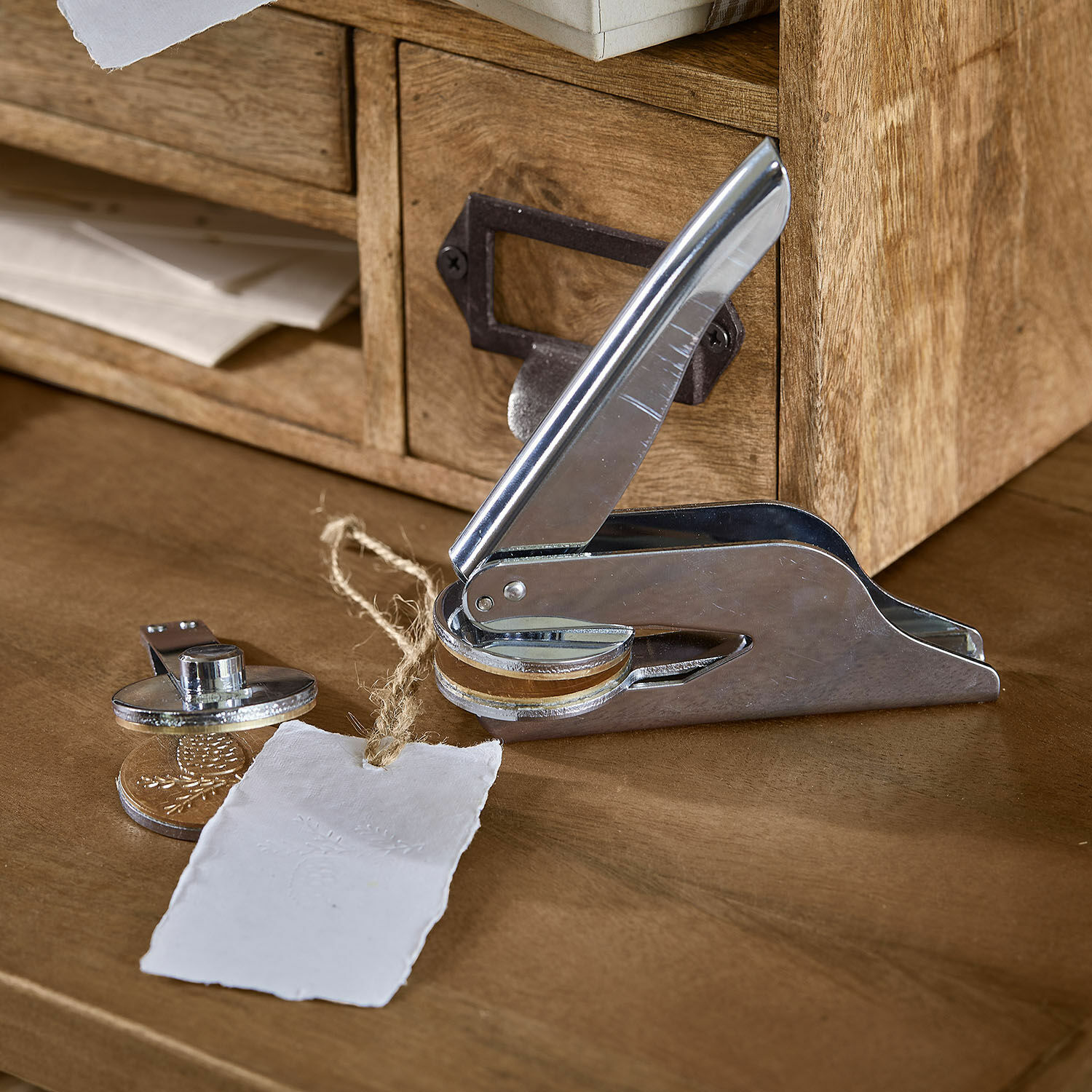 Reliëfstempel Prenisto Metalen papiersnijder met houten element op houten bureau met papieren label