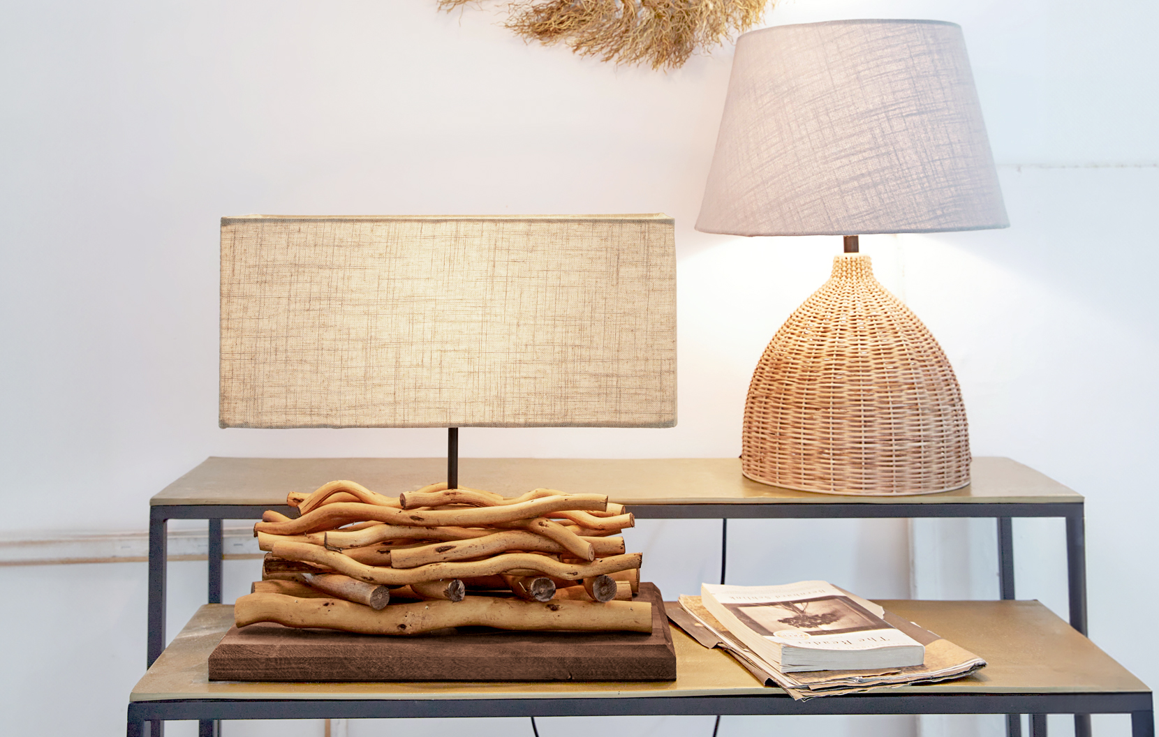 Twee tafellampen van natuurlijk hout en riet met beige lampenkappen op metalen tafel