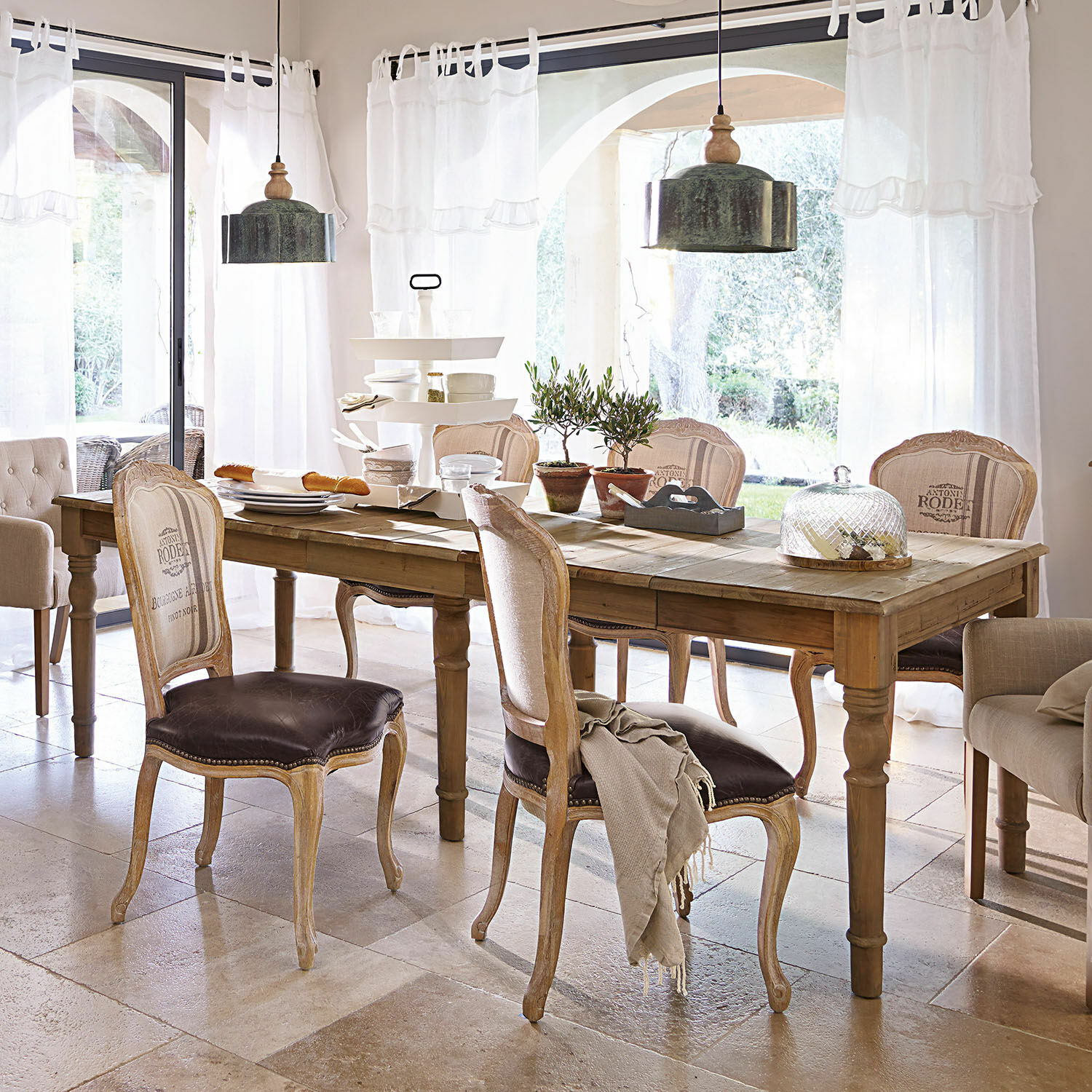 Tafel Bergenfield Eetkamer met houten tafel en vintage stoelen met bruine leren bekleding in lichte ruimte