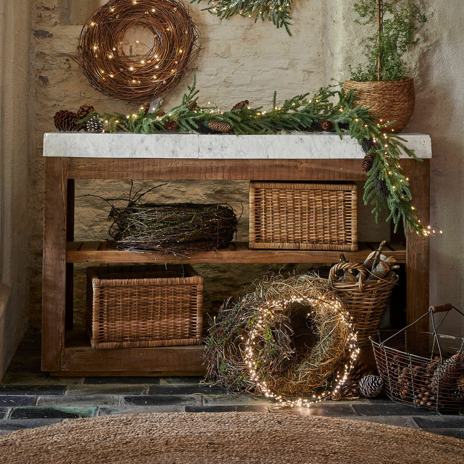 Rustieke houten tafel met marmeren blad en kerstdecoratie van takken en LED-lichtjes