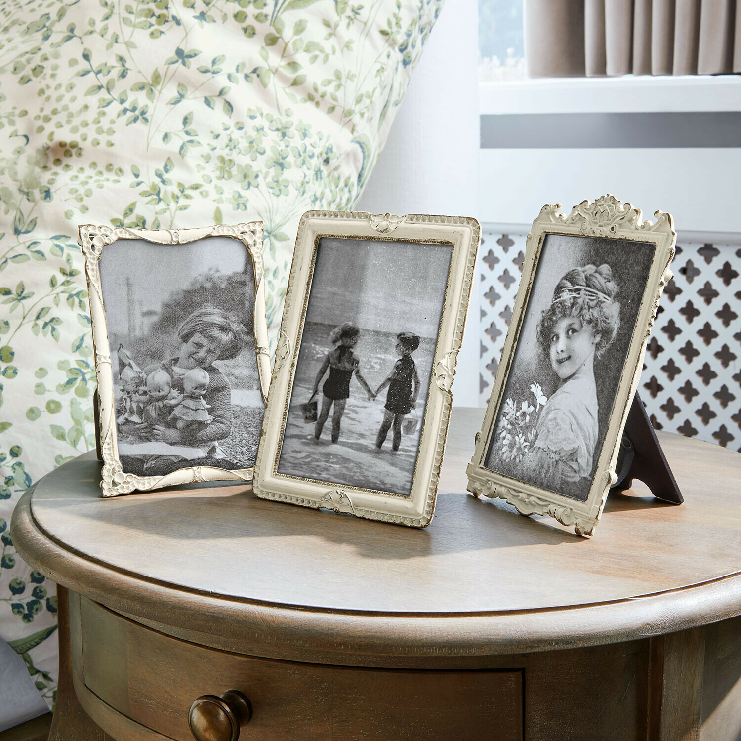 Drie decoratieve vintage fotolijsten op een houten tafel in een lichte kamer