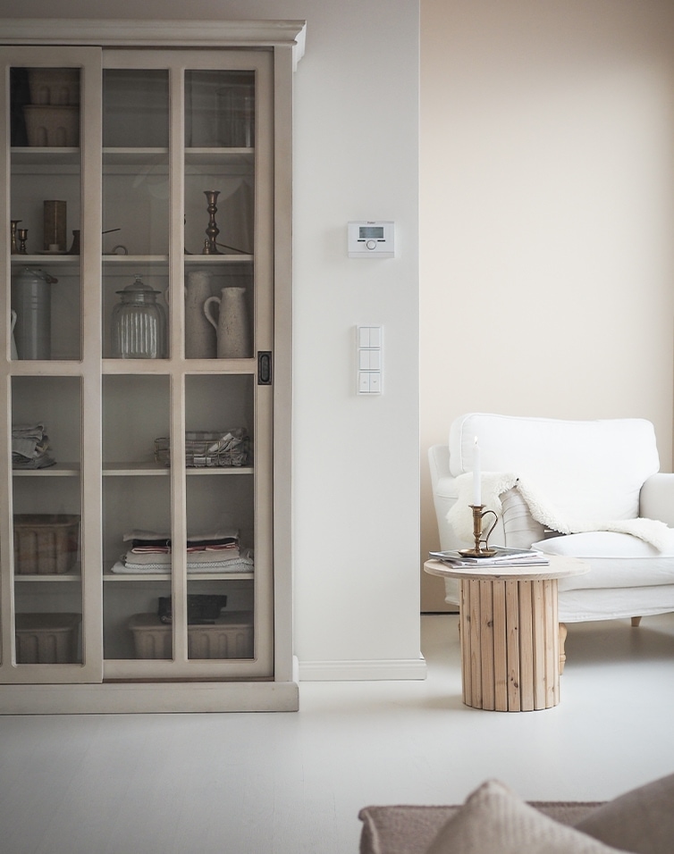 Lichte woonkamer met witte bank, houten tafel en glazen kast in Scandinavische stijl
