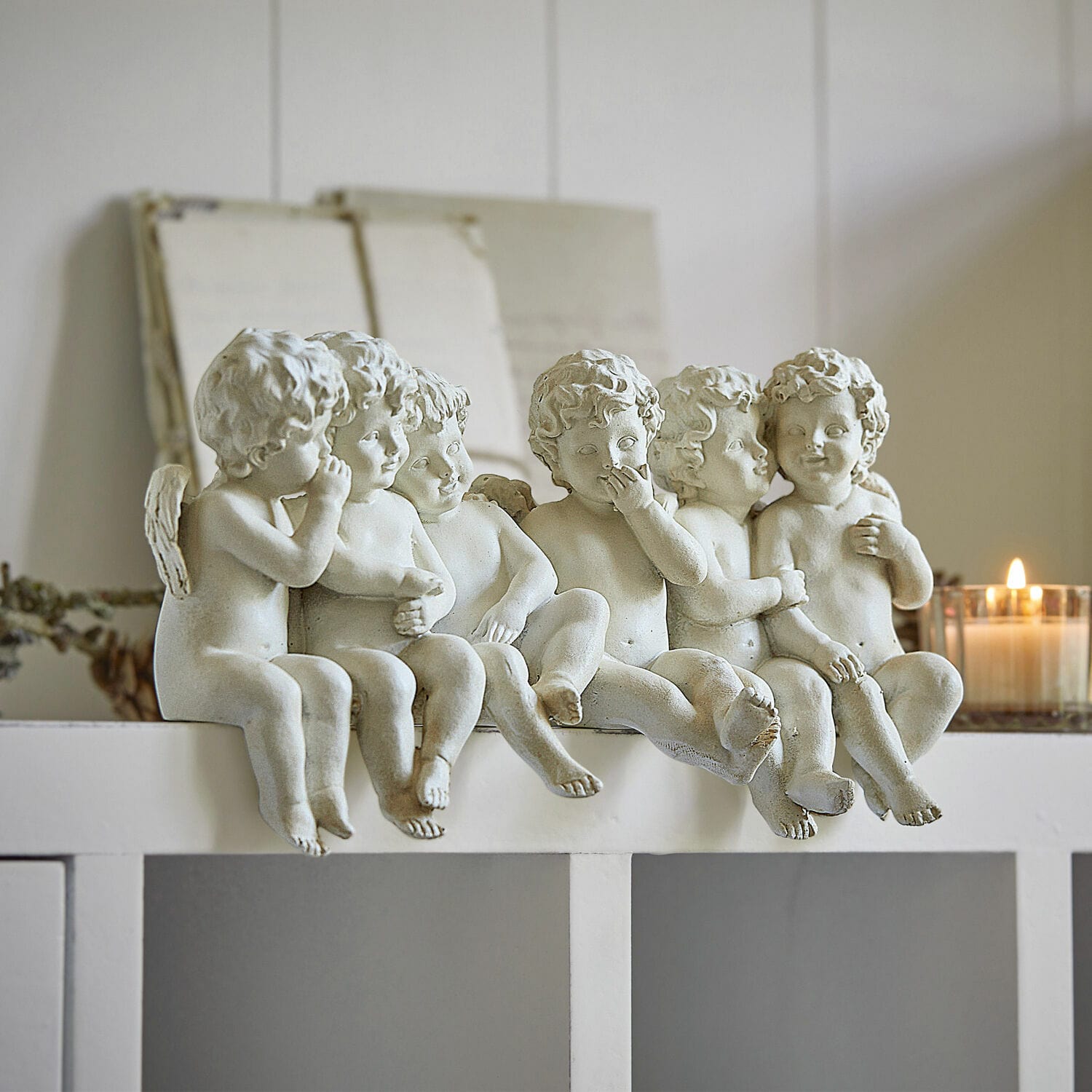 Engelen Léon Zes witte engelenfiguren van kunststof op een witte plank, interieurdecoratie