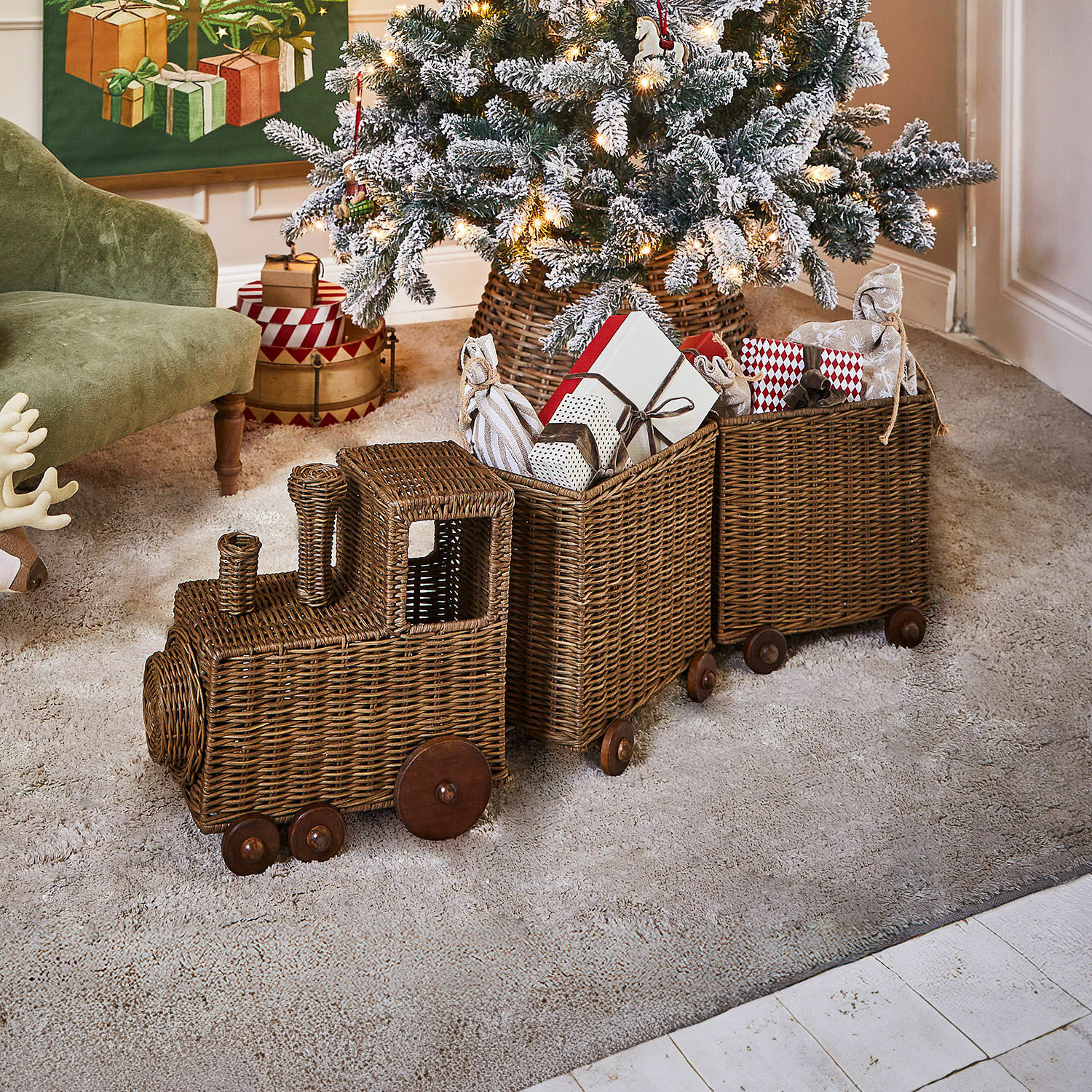 Siertrein Kareeva Bruine decoratieve rieten trein met houten wielen, gevuld met kerstcadeaus in gezellige woonkamer