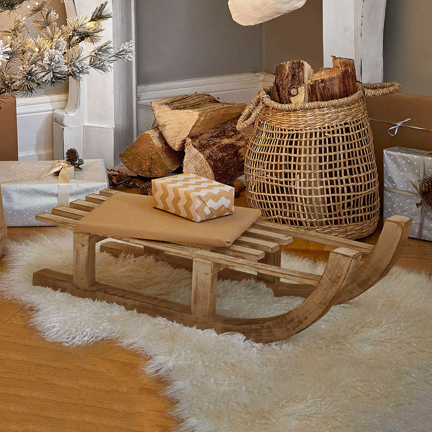 Sierslee FSC®-100% Hoekstra Decoratieve houten slee op witte schapenvacht met cadeaus en mand met houtblokken