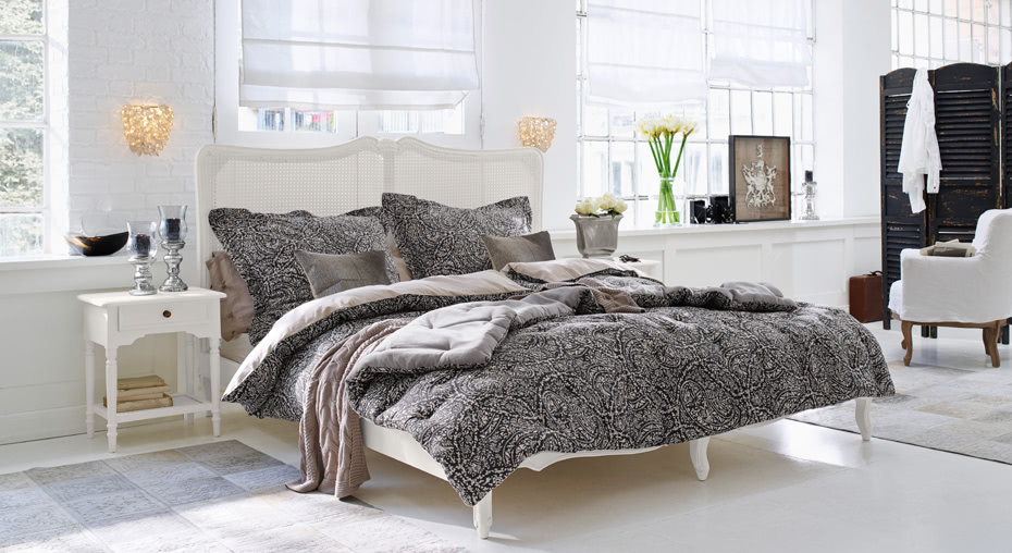 Slaapkamer in landelijke stijl met wit bed en zwart-grijs patroon beddengoed