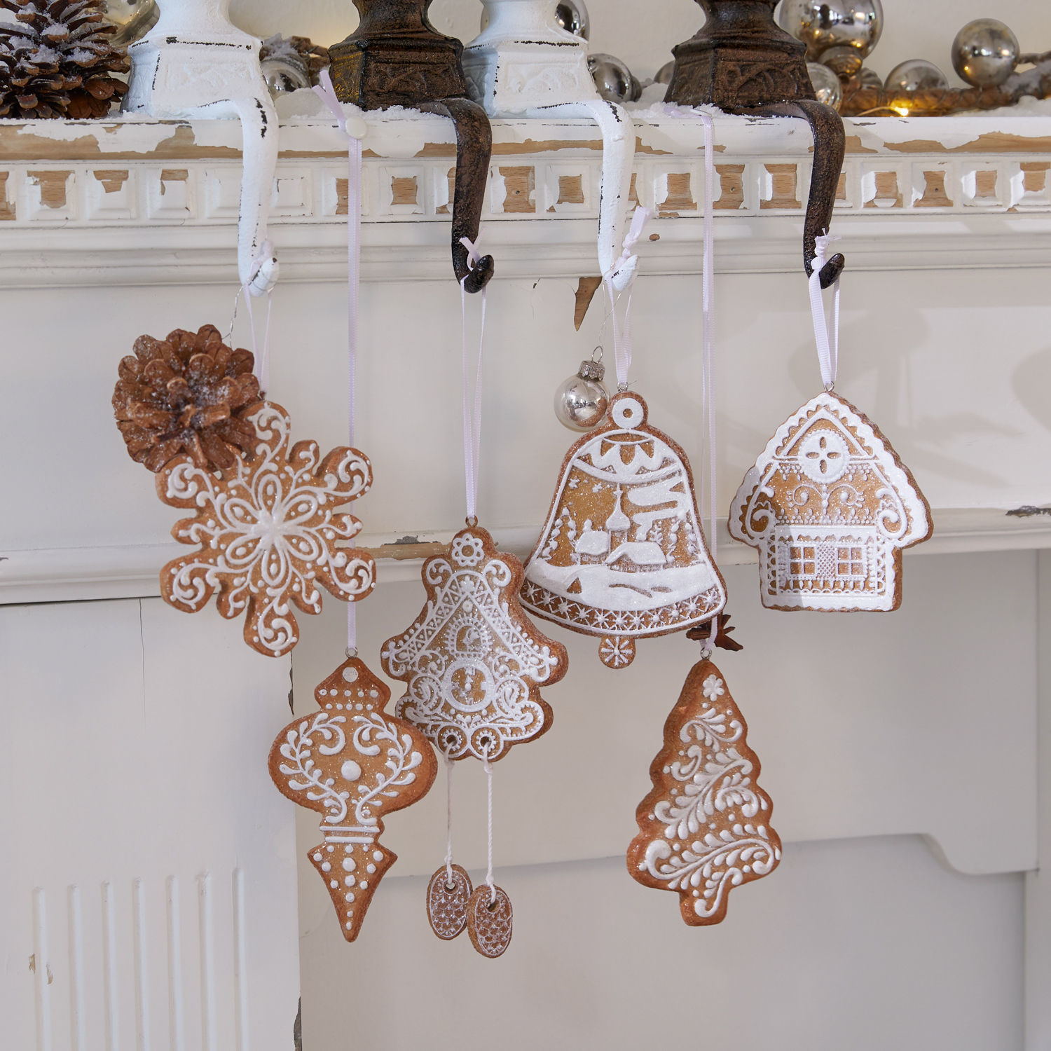 Set kerstversieringen van peperkoek met witte glazuur, hangend aan haken bij de open haard, feestelijke decoraties