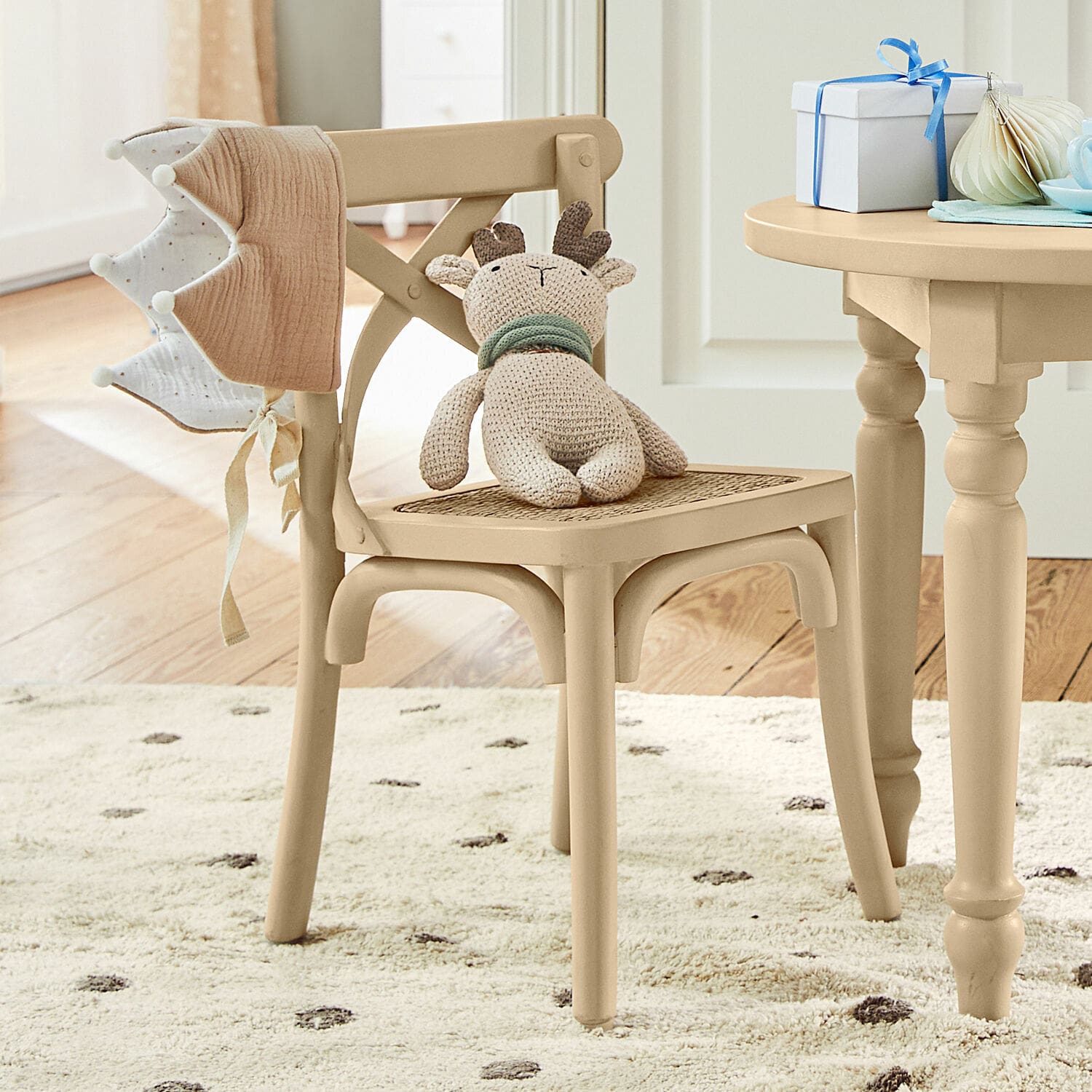 Kinderstoel Sourila Beige houten stoel met gevlochten zitting en gebreide rendierknuffel in kinderkamer