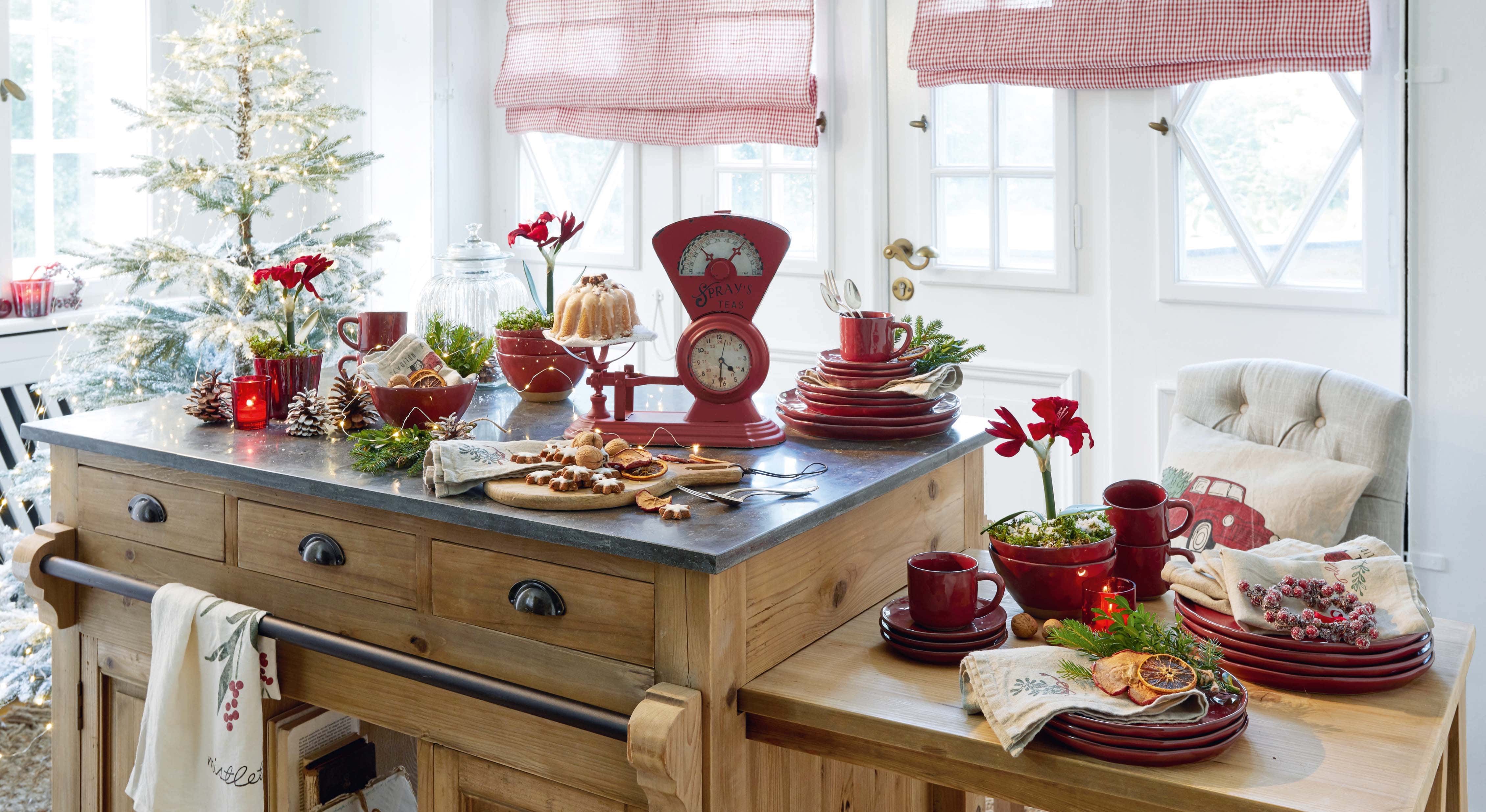 Keuken met houten eiland, rood keramisch servies en kerstdecoratie met LED-lichtjes