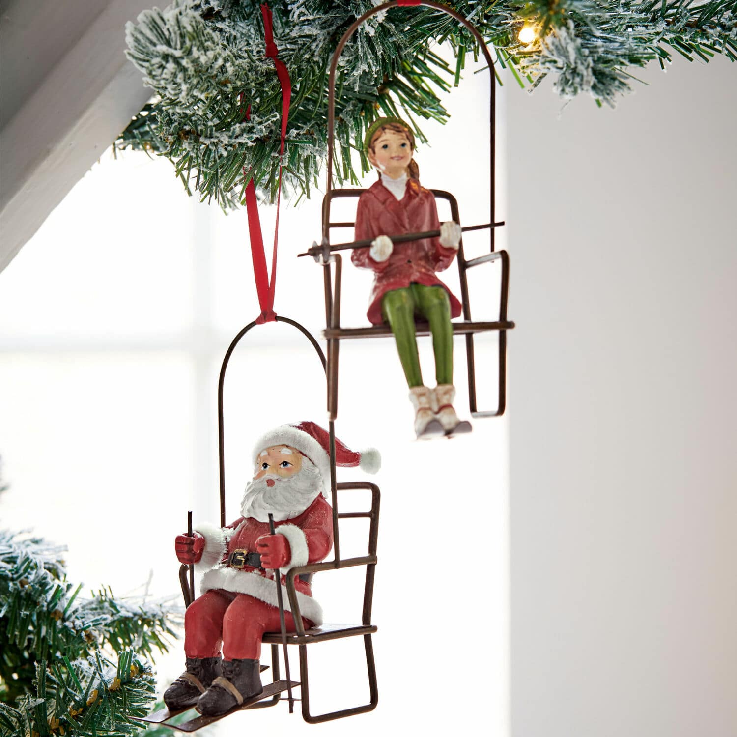 Kerstversiering met hangende figuren van de kerstman en meisje op metalen stoelen