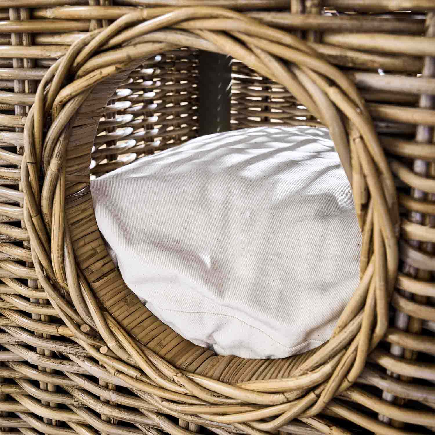 Ronde opening van een rotan mand met wit kussen, natuurlijk materiaal en kleur