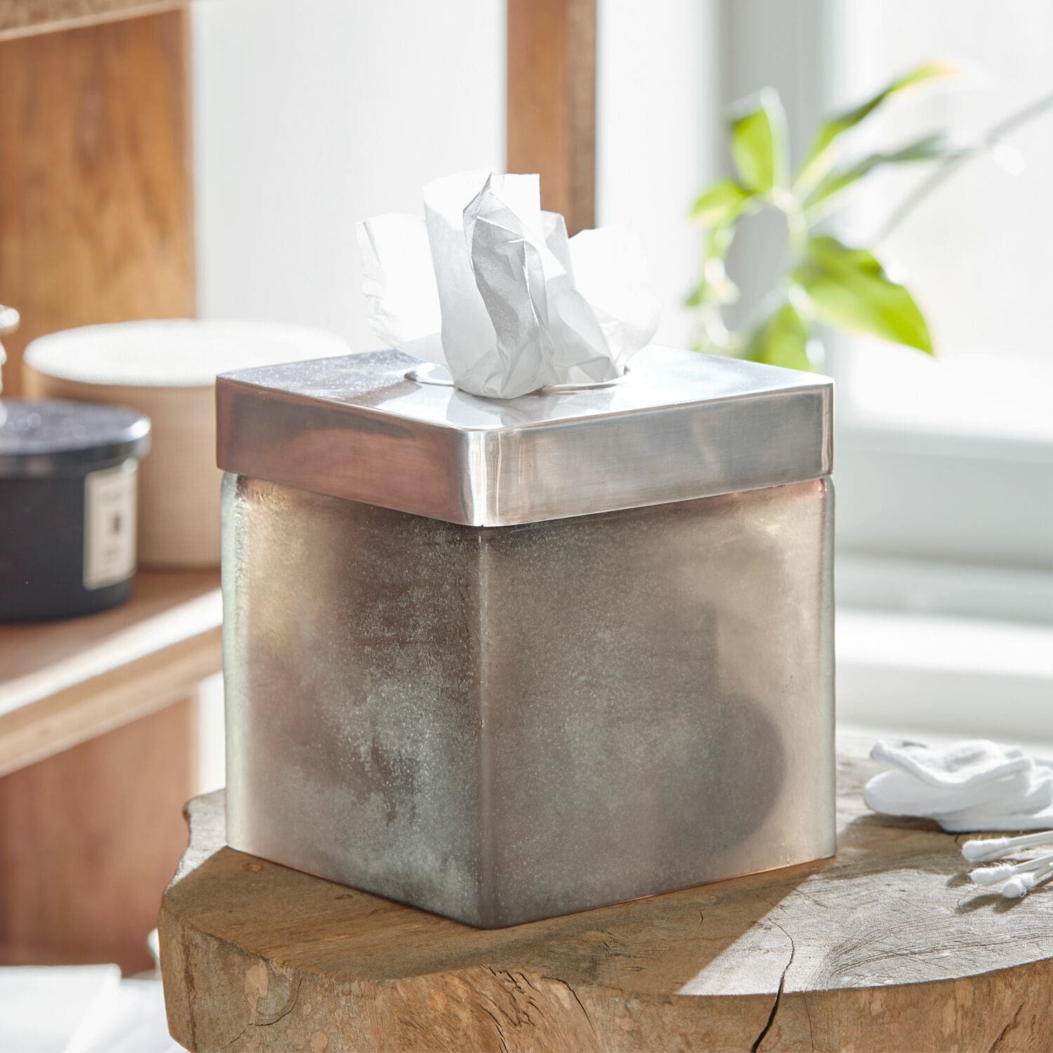 Vierkante zilverkleurige metalen tissuebox met geborsteld oppervlak op houten tafel
