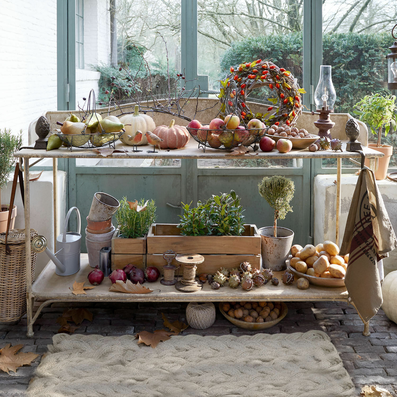 Plantentafel Banners Metalen tuintafel met herfstdecoraties en lichte groenten voor een groene deur