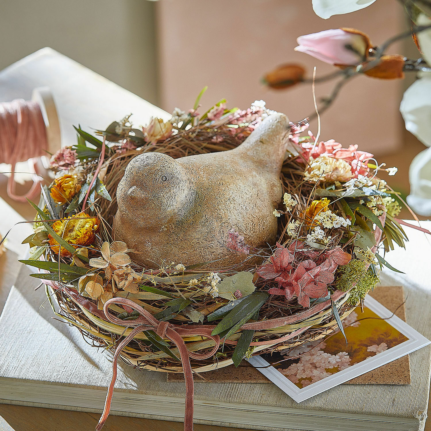 Nest Bravilex Decoratieve keramische vogel in nest van gedroogde bloemen en bladeren op tafel