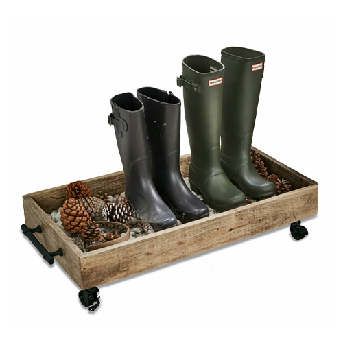 Houten dienblad op wieltjes met zwarte en groene laarzen en dennenappels, praktische schoenenorganizer