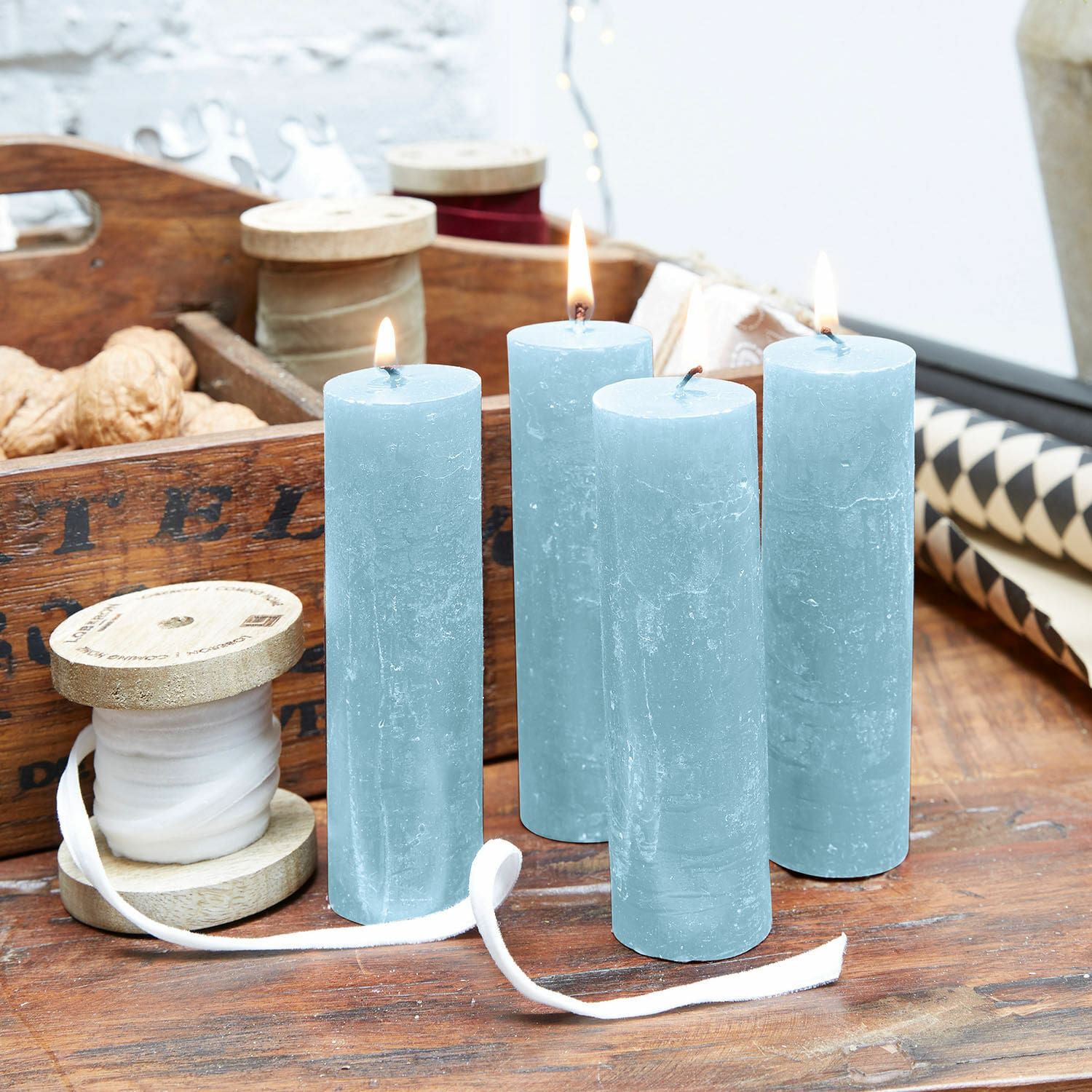 Kaars set van 4 Muriel Set van vier blauwe kaarsen van natuurlijke was op houten tafel met decoraties