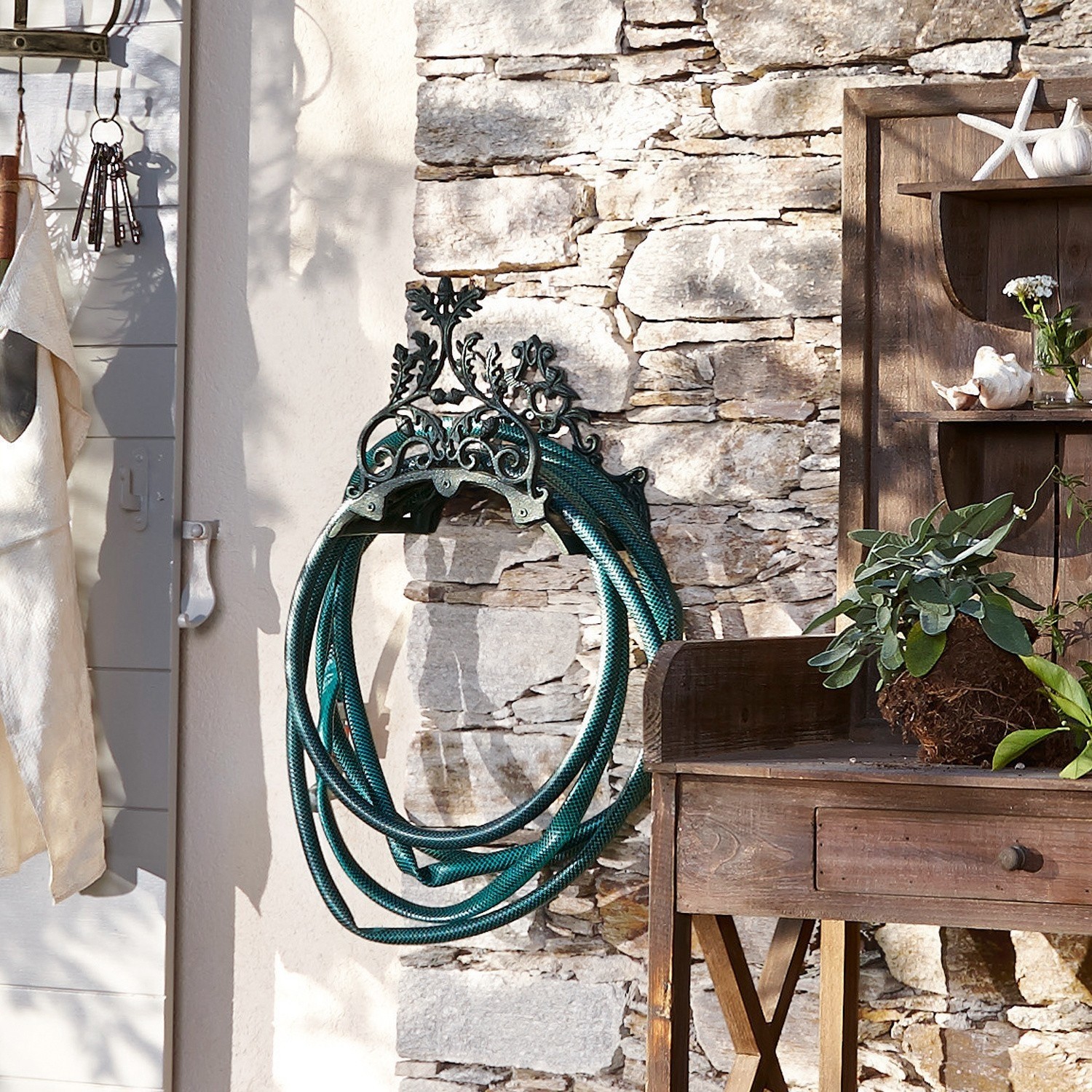 Tuinslanghaspel Mathis Decoratieve metalen wandhouder voor tuinslang in vintage stijl aan stenen muur