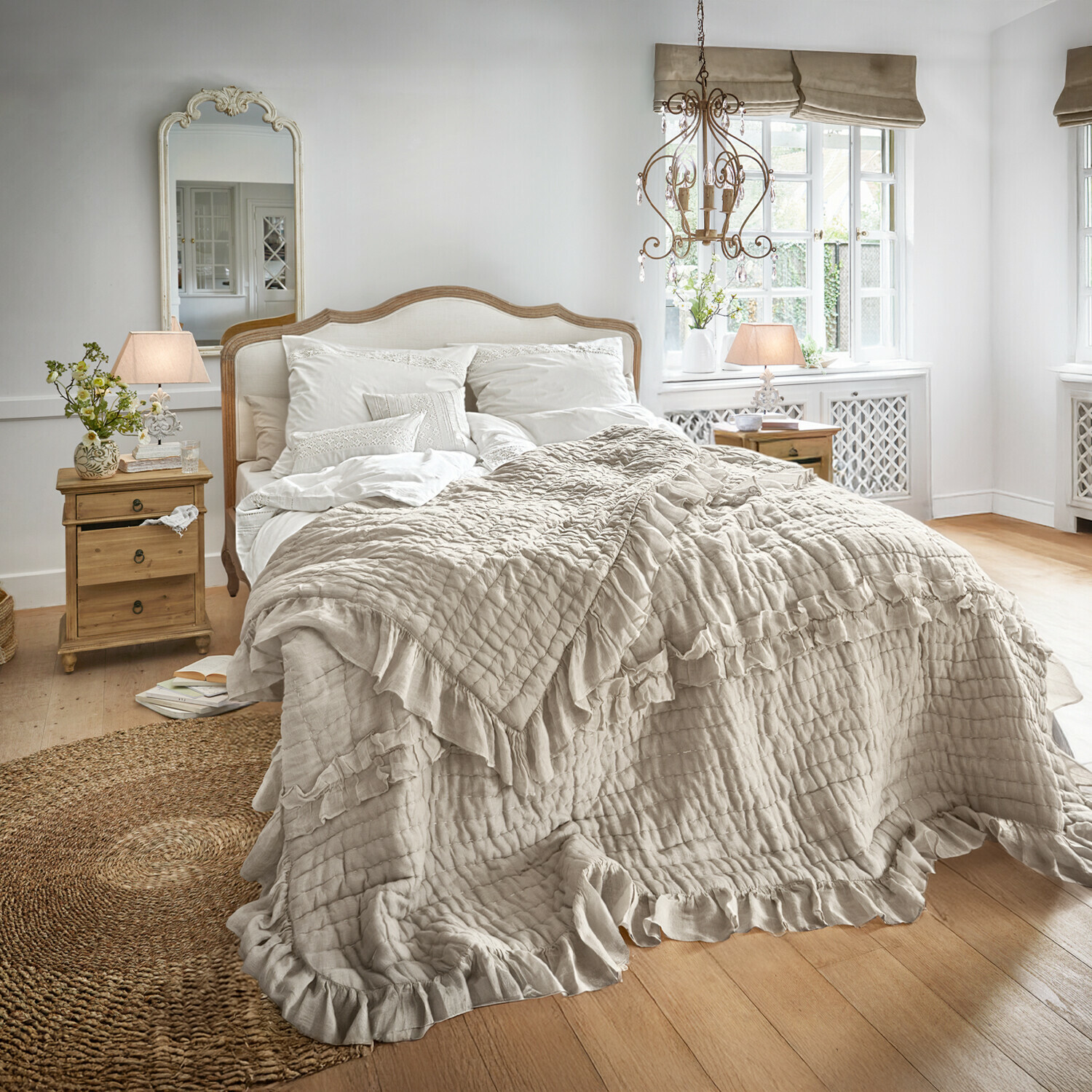 Gezellige slaapkamer met beige sprei met ruches op bed en vintage houten meubels