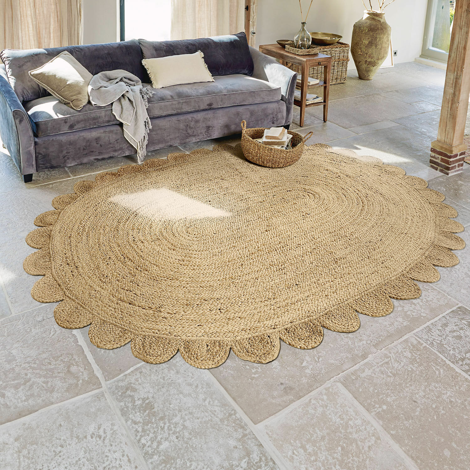 Ronde jute vloerkleed in natuurlijke kleur met decoratieve rand in woonkamer met grijze bank