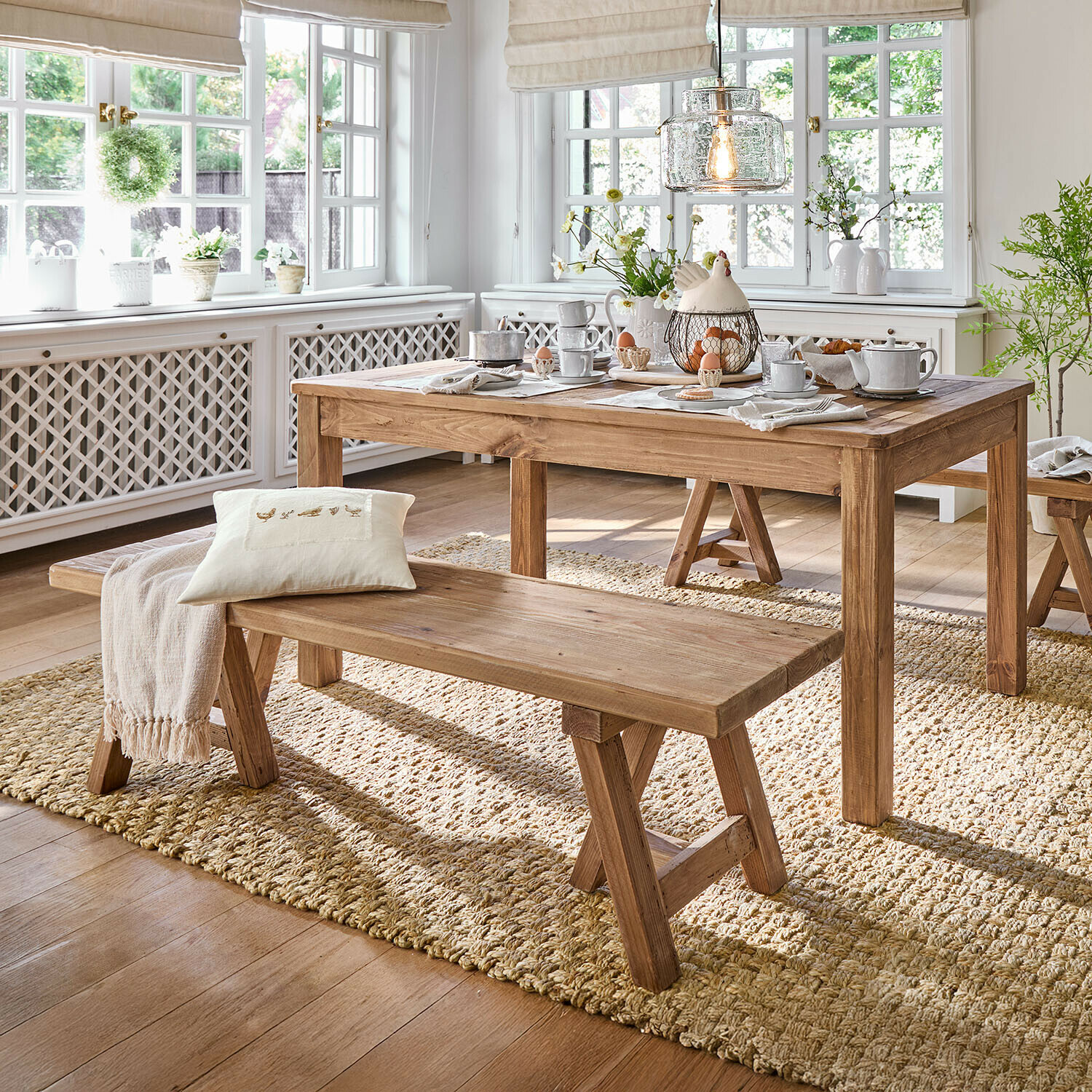 Bank Amherst Eetkamer met houten tafel en bank op natuurlijke vloerkleed, lichte ruimte met grote ramen