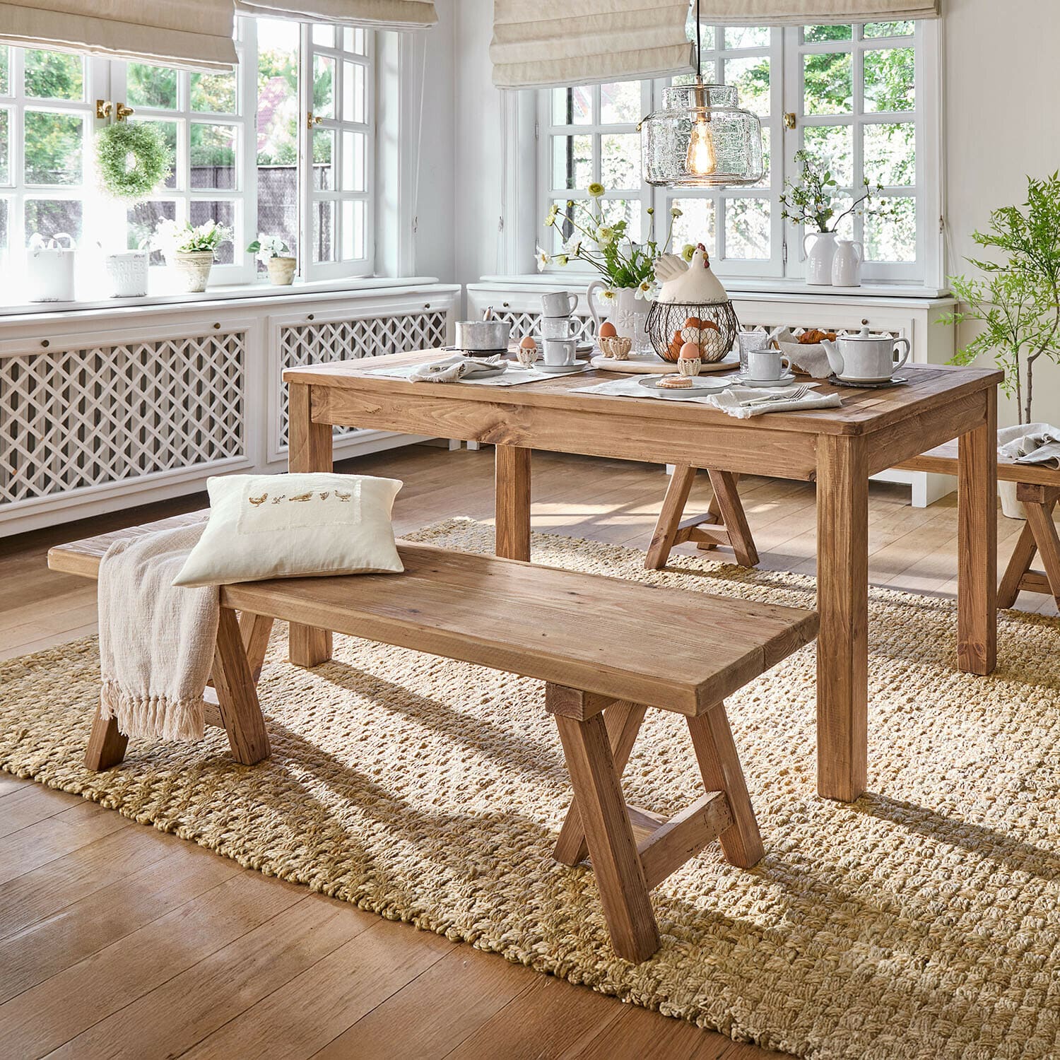 Bank Amherst Eetkamer met houten tafel en bank op natuurlijke vloerkleed, lichte ruimte met grote ramen