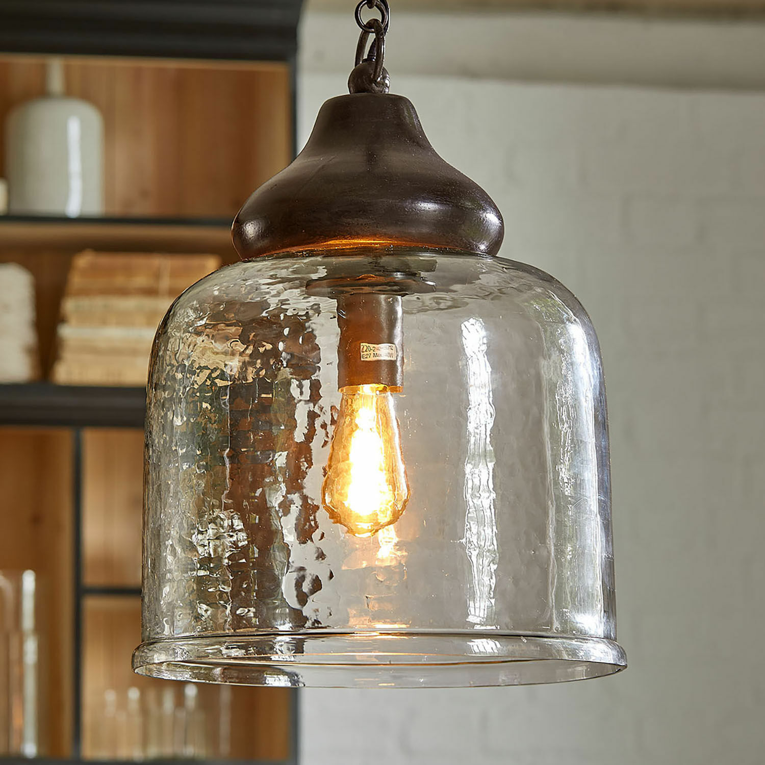 Glazen hanglamp met koperen afwerking en warm licht, industrieel design