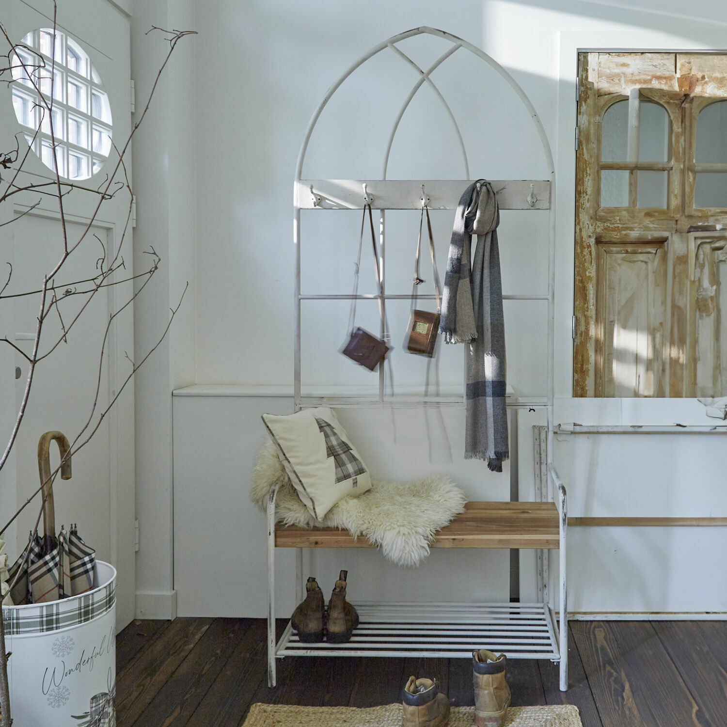 Witte metalen bank met houten zitting en vintage kapstokken voor hal