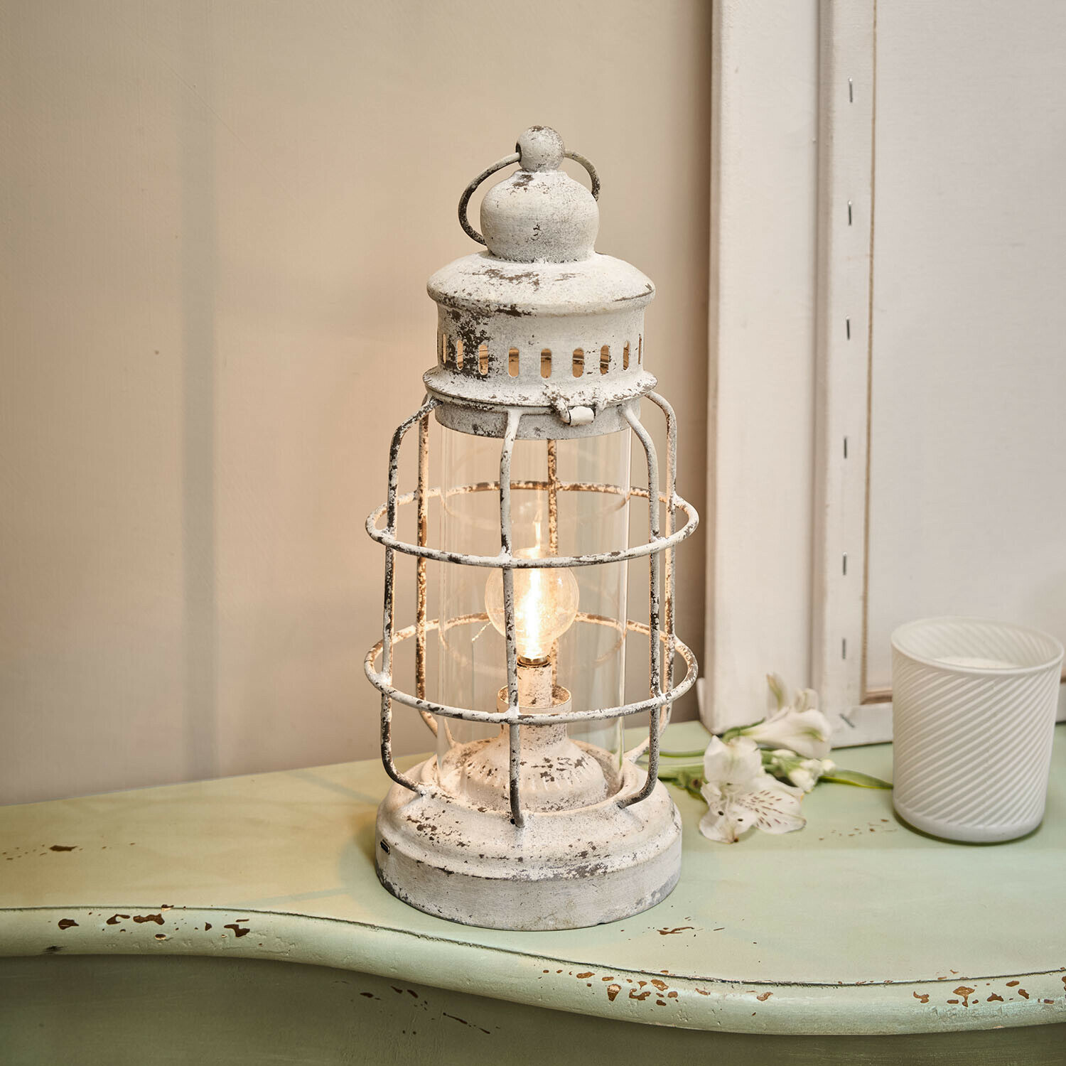 Witte metalen lantaarn met verweerde look en gloeilamp, vintage interieurdecoratie