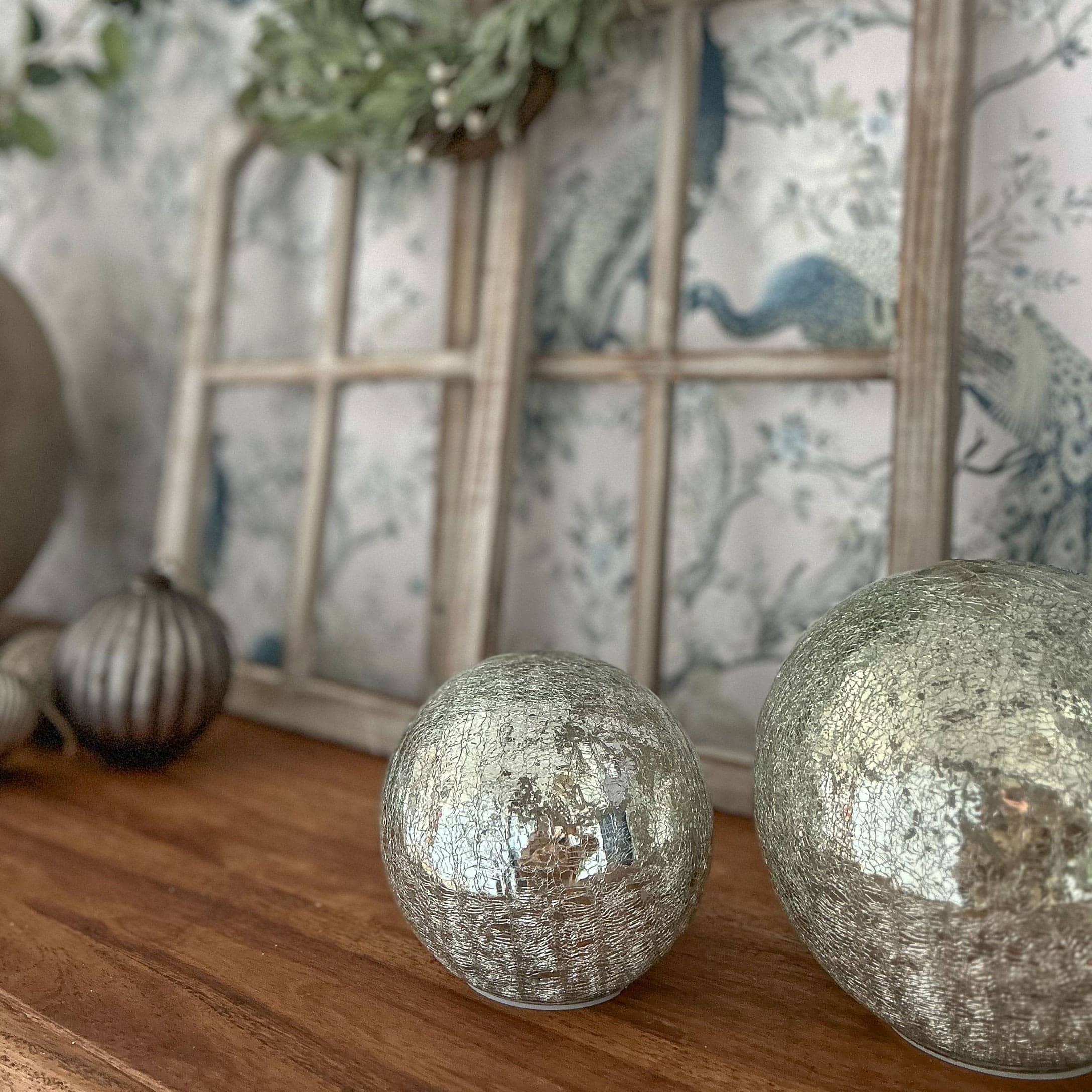 Decoratieve zilveren bollen met gebarsten oppervlak op houten tafel voor interieurdecoratie