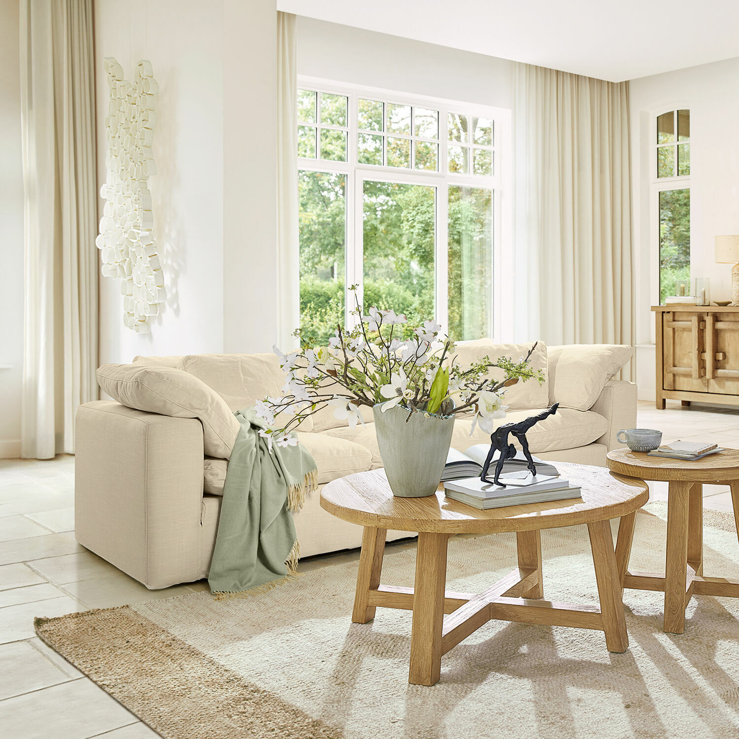 Bank Queensbridge Lichtbeige stoffen bank in moderne woonkamer met houten salontafel en bloemendecoratie
